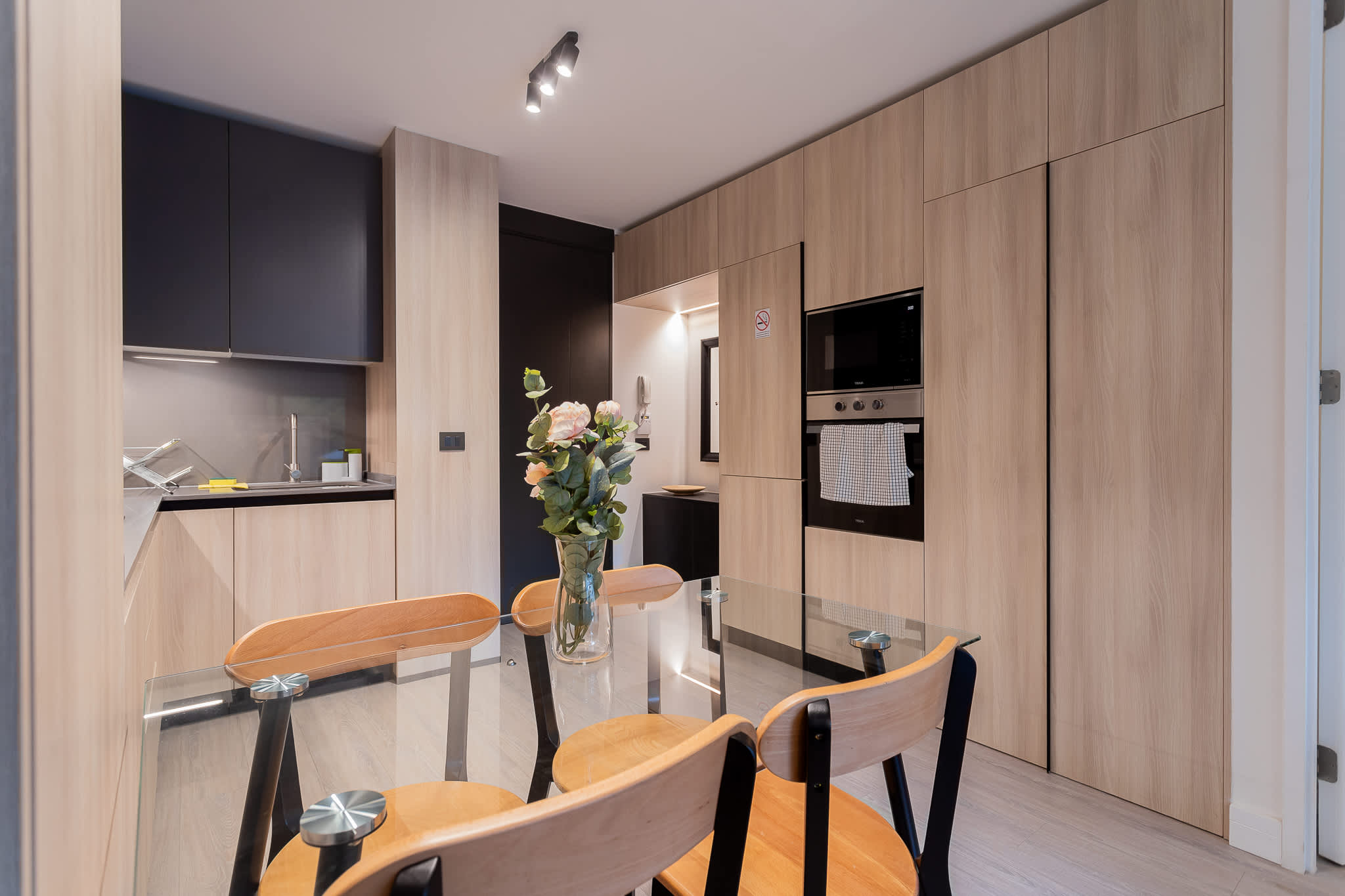 Experience modern living in this sleek kitchen, featuring stylish cabinetry and a cozy dining area perfect for meals and gatherings.