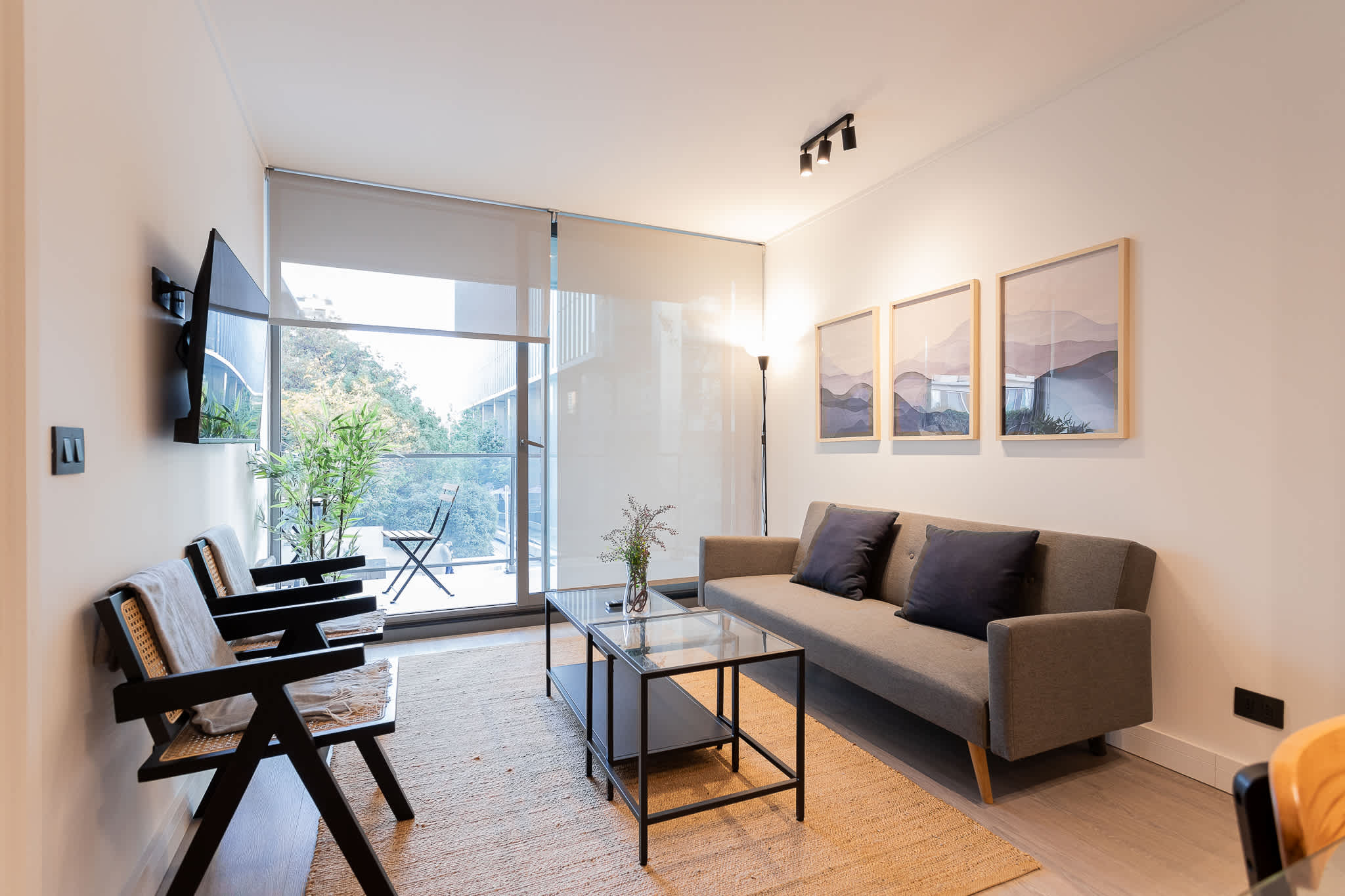 Experience modern comfort in this stylish living room, featuring large windows and a serene view. Perfect for relaxation and unwinding.