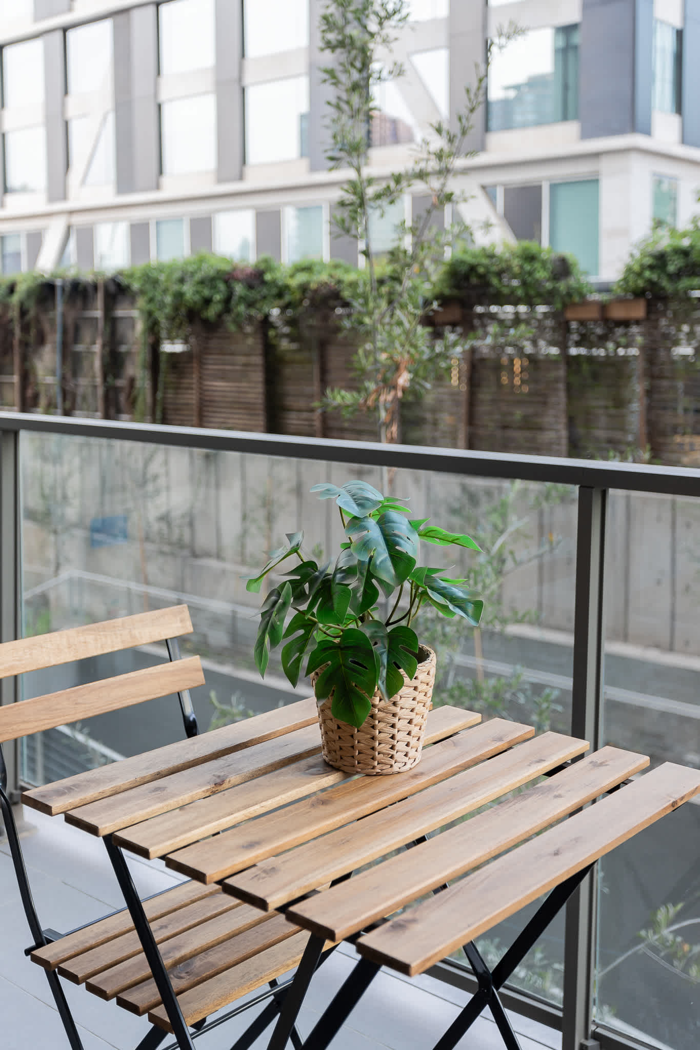 Enjoy a peaceful moment on the balcony with a cozy table and plant, perfect for sipping coffee and soaking in the urban vibe.