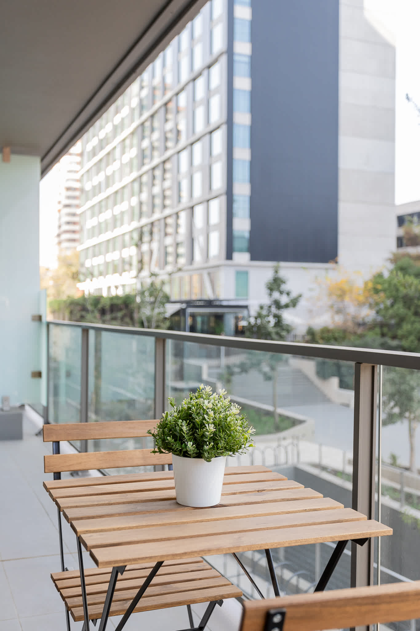 Enjoy a cozy moment on your private balcony, surrounded by modern architecture and a touch of greenery.