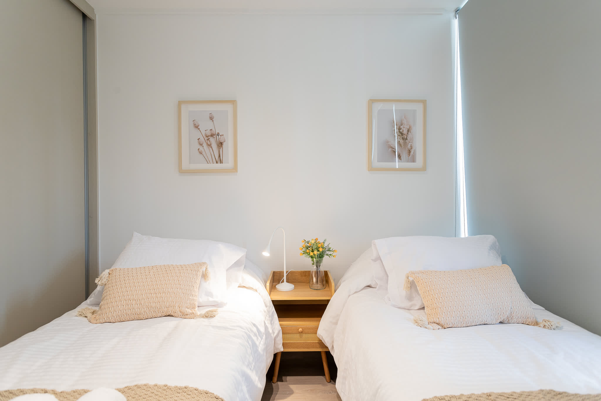 Relax in this cozy bedroom featuring two comfortable beds, stylish decor, and a warm ambiance perfect for a restful stay.