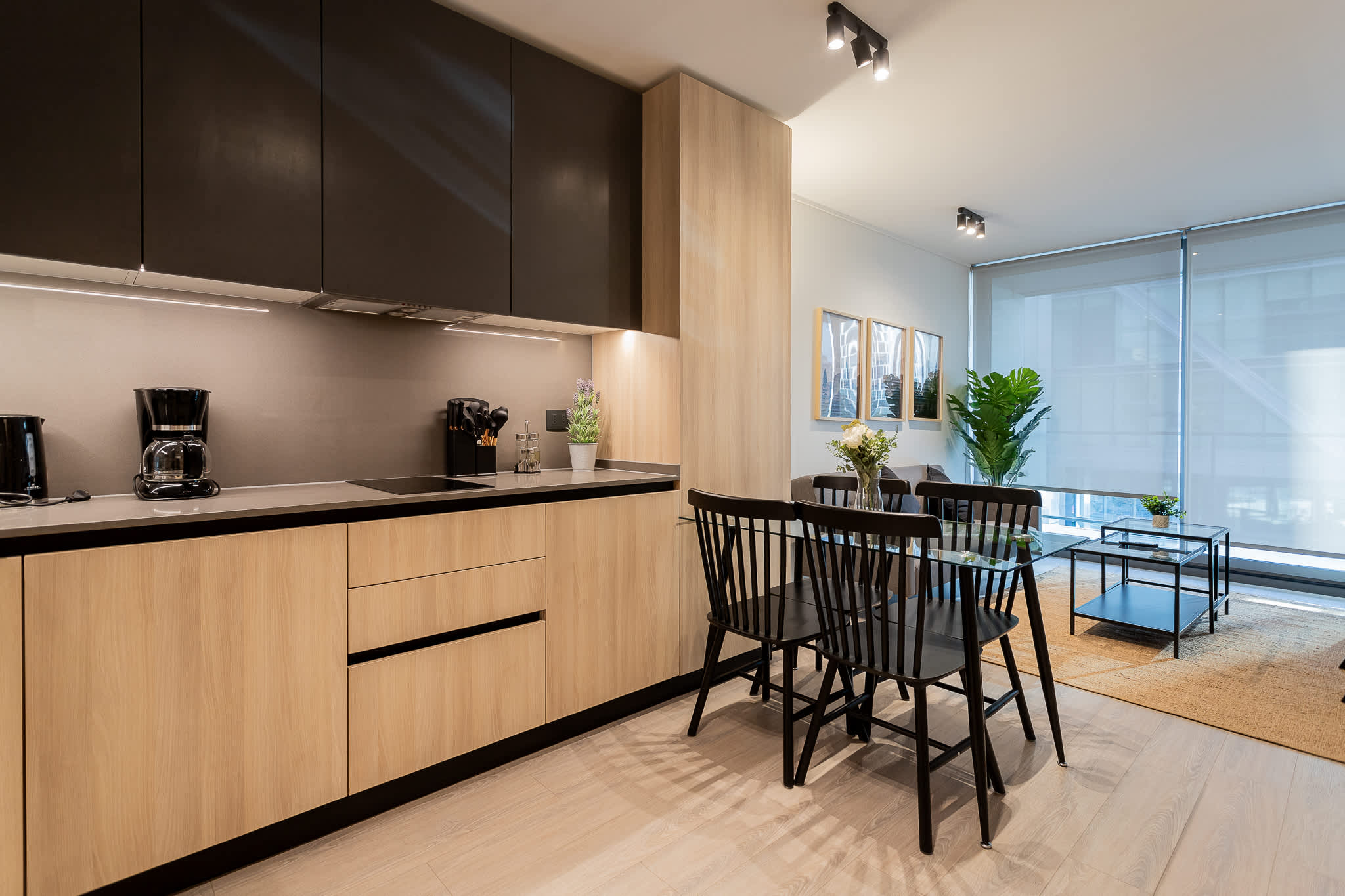 Experience modern living in this stylish kitchen, featuring sleek cabinetry and a cozy dining area perfect for meals and gatherings.
