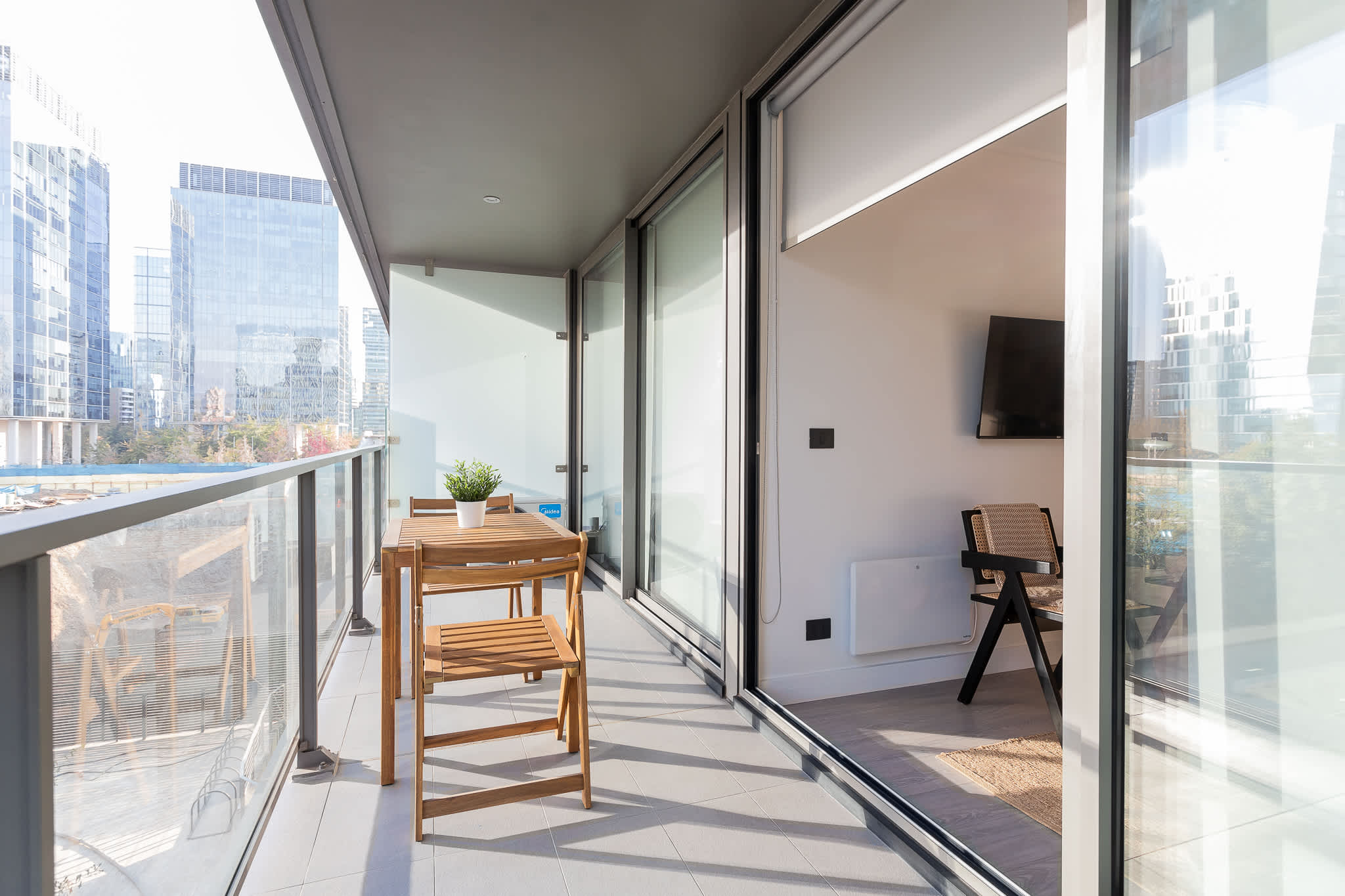 Enjoy a serene moment on your private balcony with stunning urban views, perfect for relaxation after a day of exploring the city.