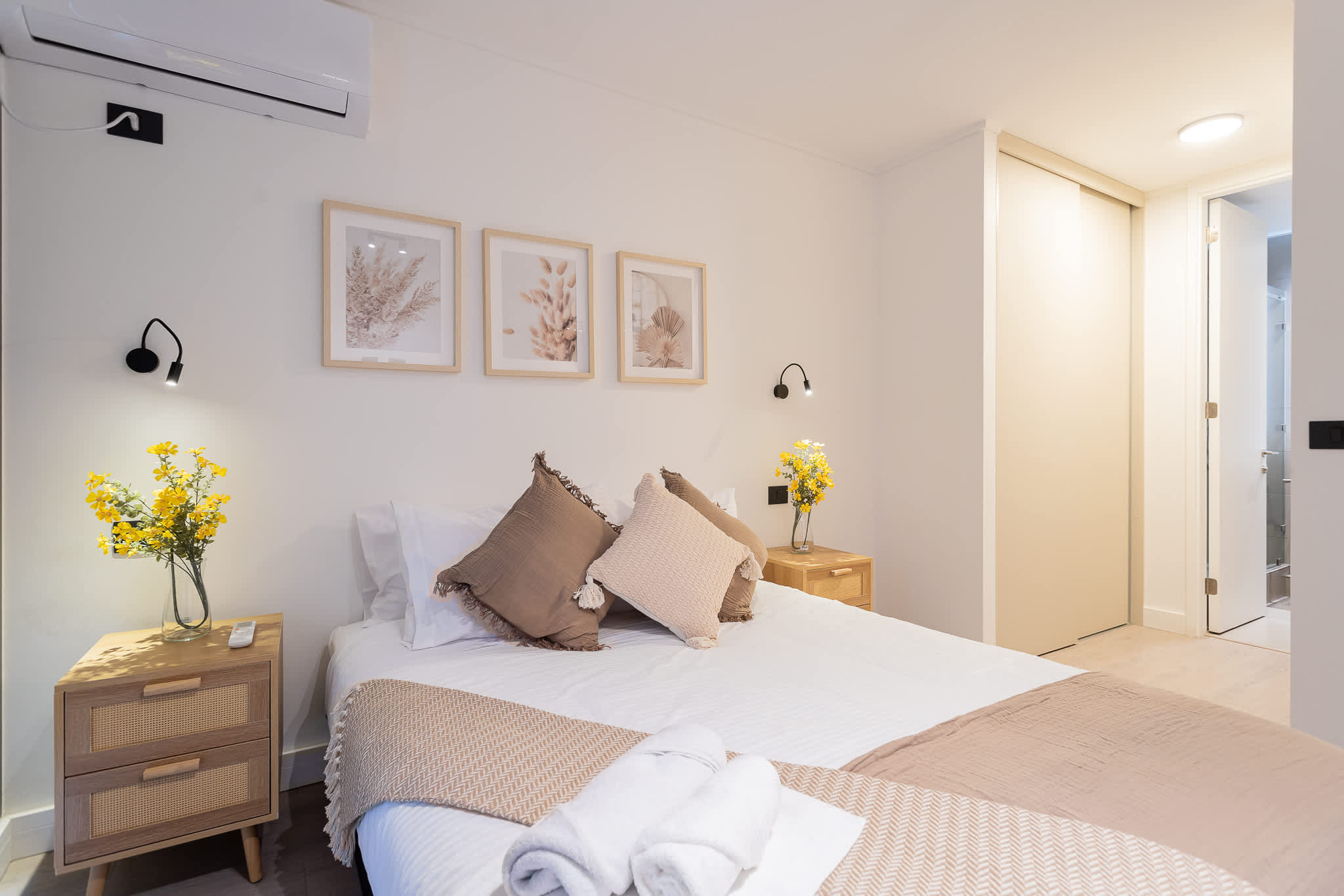 Relax in this serene bedroom with soft lighting, cozy decor, and fresh flowers for a touch of nature.