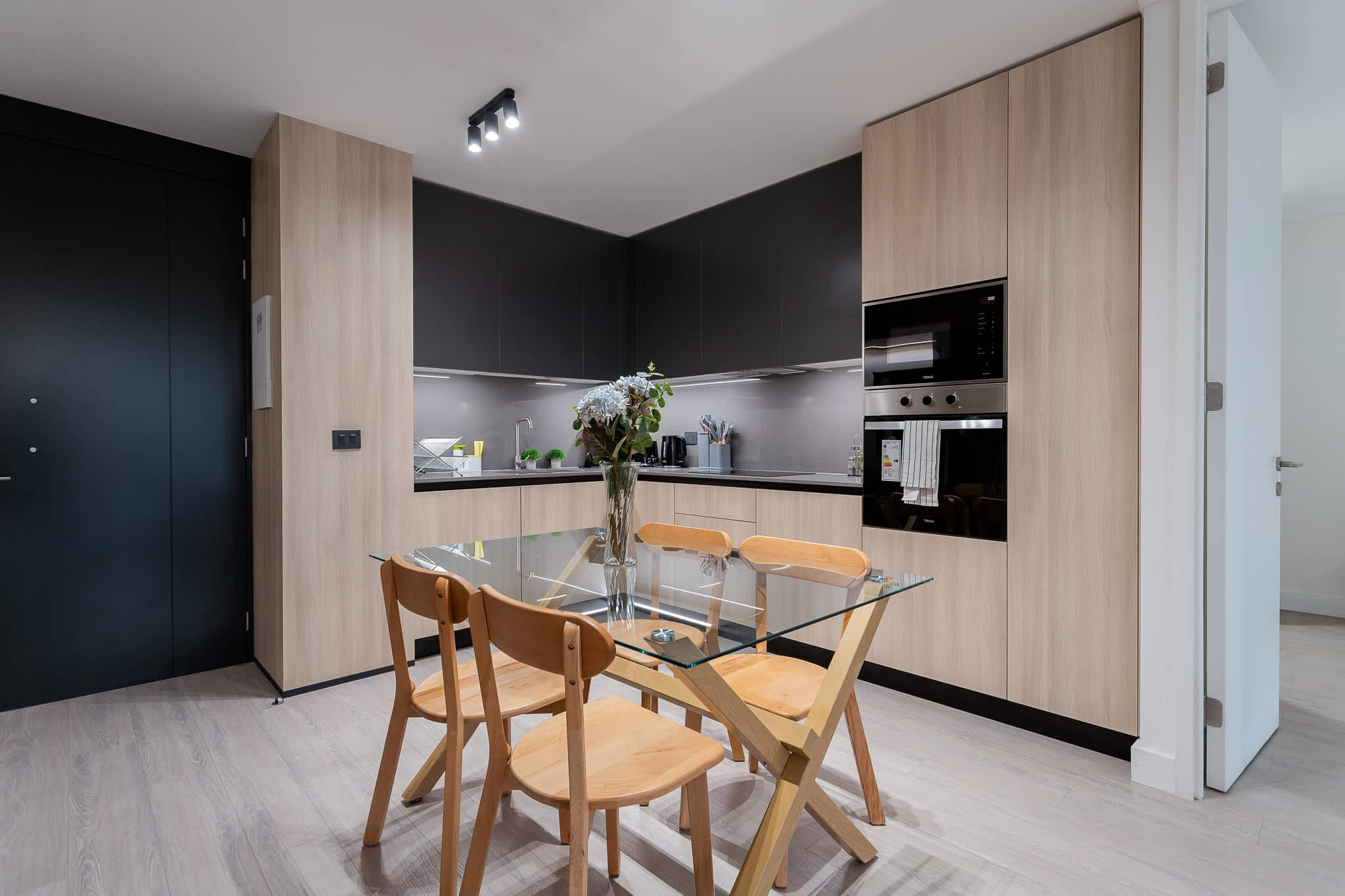 Experience modern living in this stylish kitchen, featuring sleek cabinetry and a cozy dining area perfect for meals and gatherings.