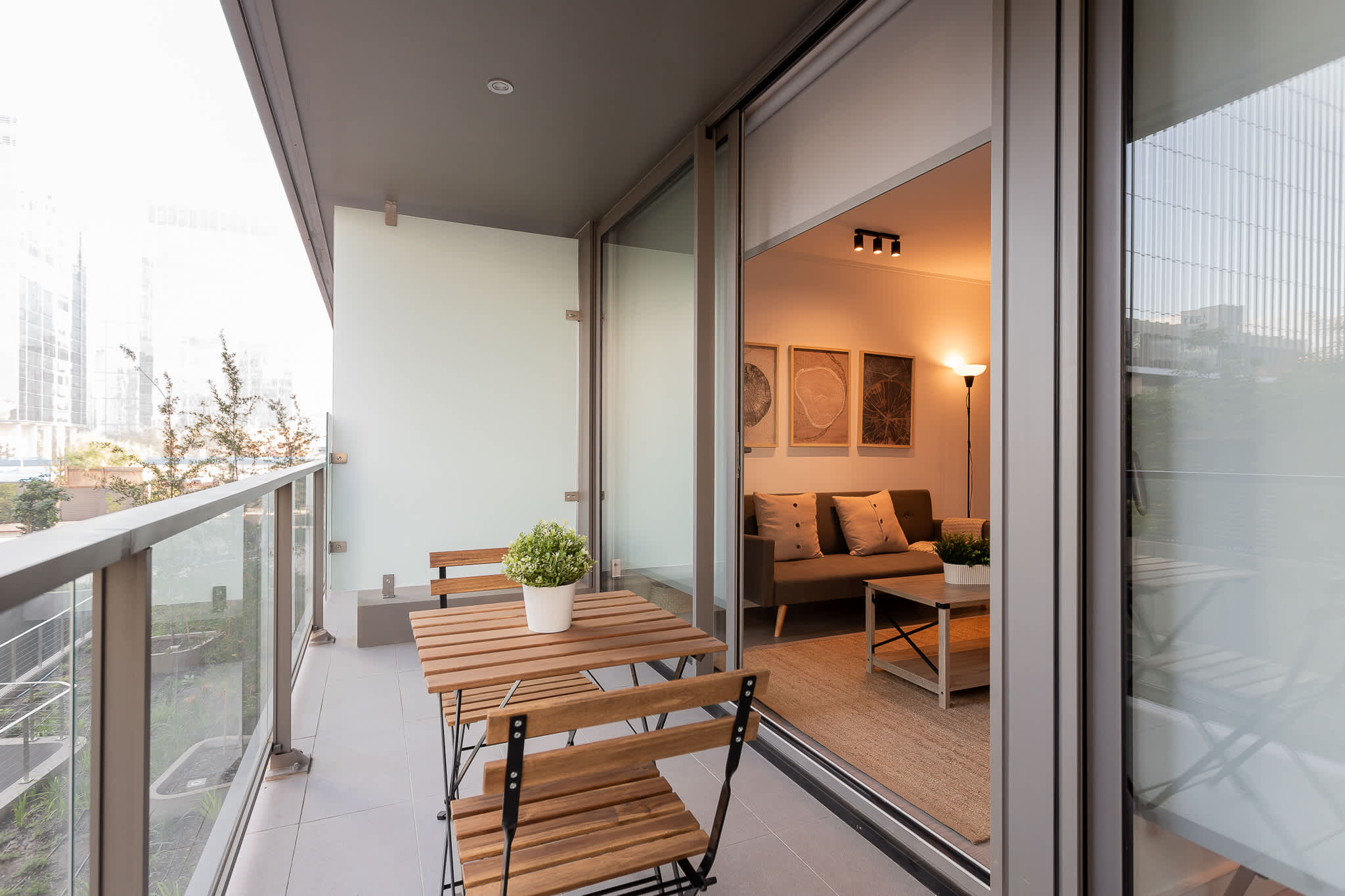 Enjoy a serene morning coffee on your private balcony with city views, seamlessly connected to a cozy living space.