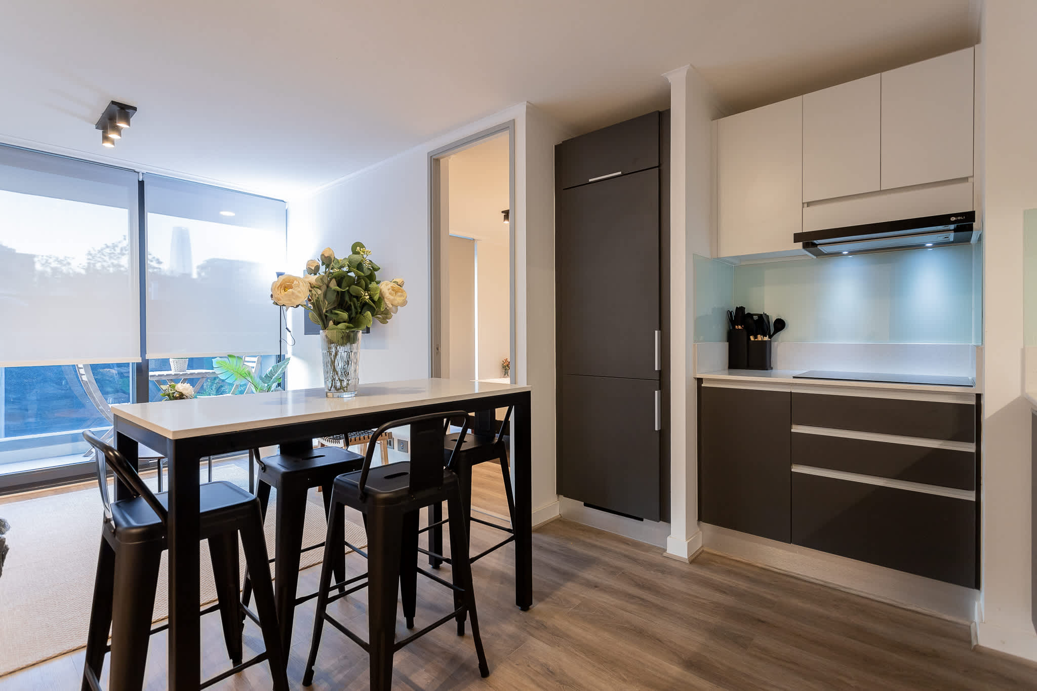 Experience modern living in this stylish kitchen, featuring sleek cabinetry, bar seating, and abundant natural light for a welcoming atmosphere.