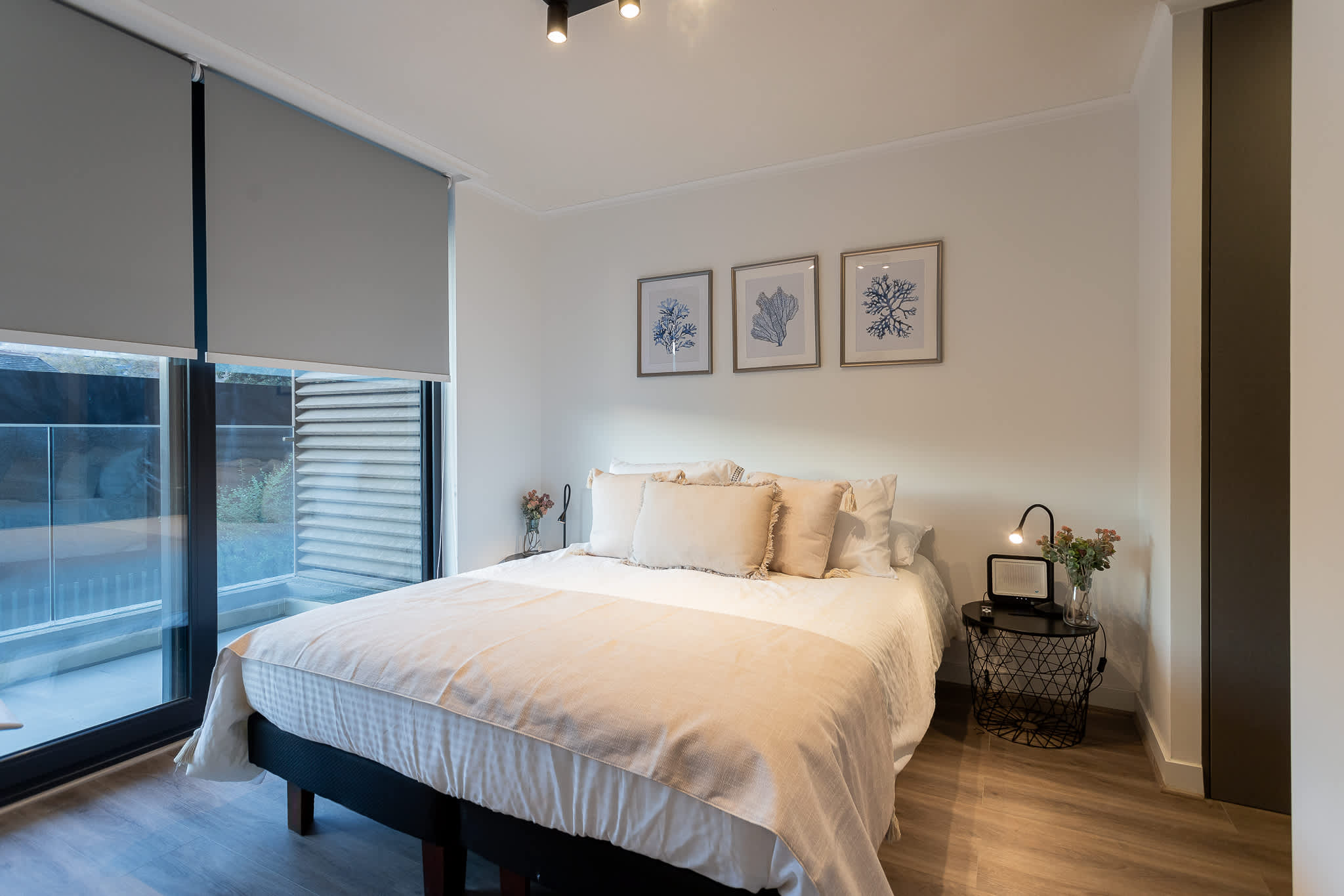 Relax in this serene bedroom featuring a plush bed, stylish decor, and abundant natural light for a restful stay.