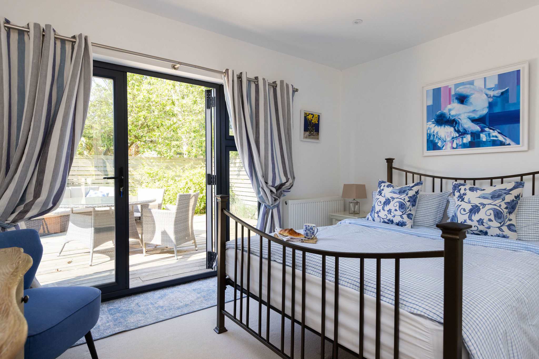This serene bedroom offers a peaceful escape with French doors leading to a lovely outdoor space.
