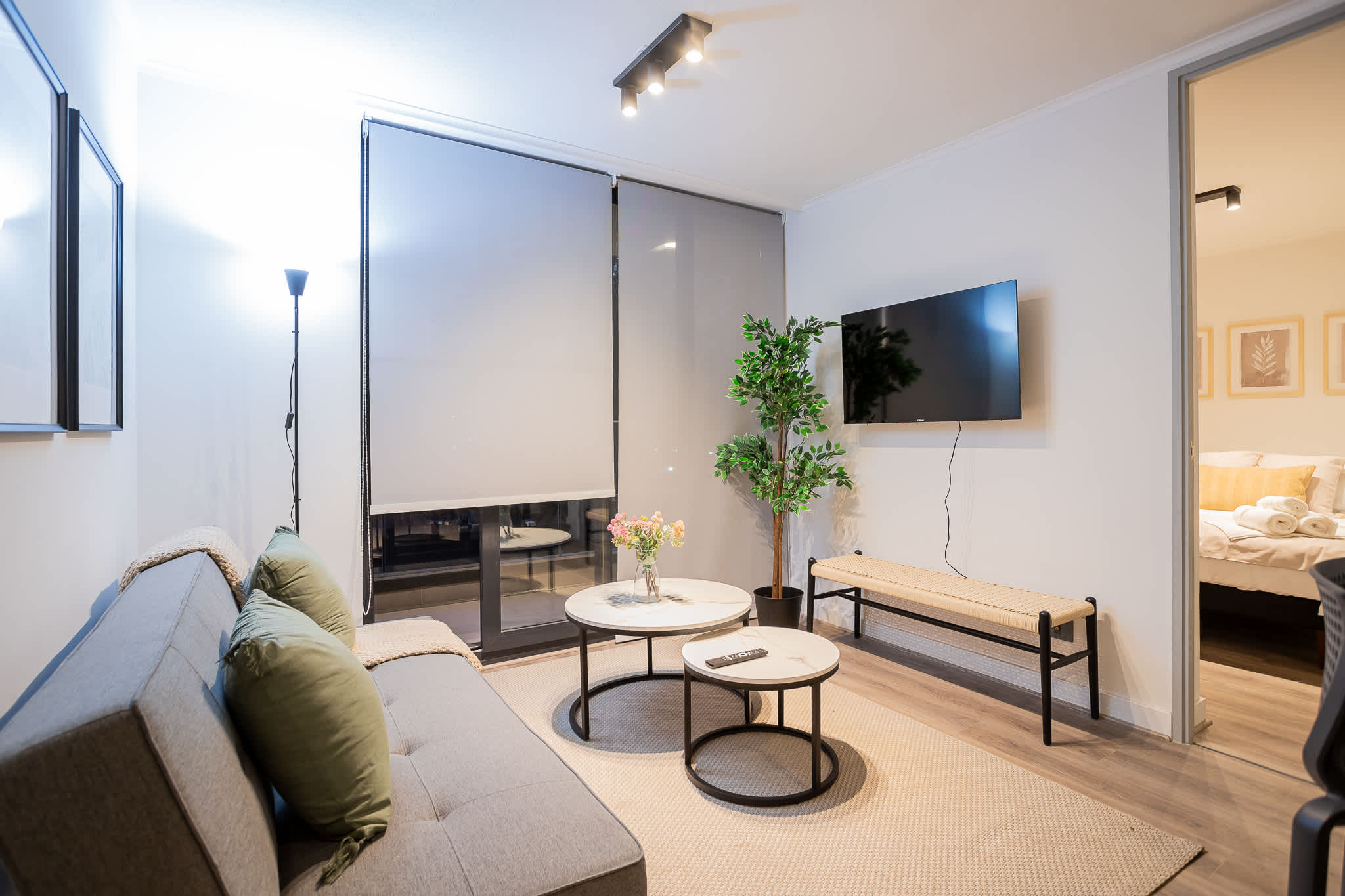 Cozy living room with modern decor, perfect for relaxing evenings with a wall-mounted TV and stylish coffee tables.