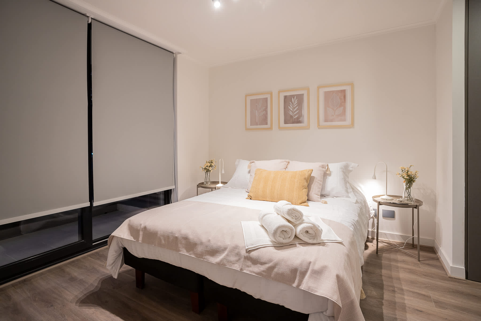 Relax in this serene bedroom with cozy linens, soft lighting, and elegant decor, perfect for a restful stay.