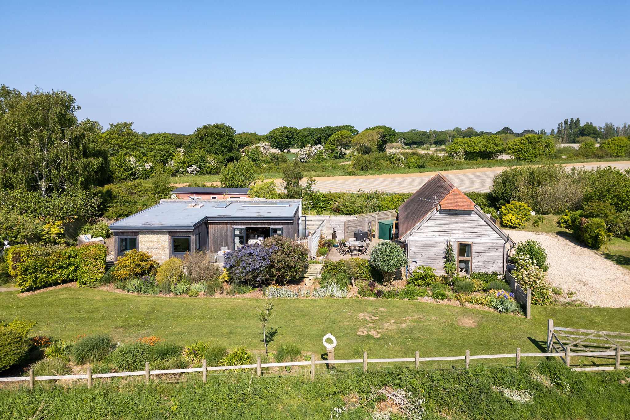 Peaceful rural setting, surrounded by expansive gardens and farmland views.