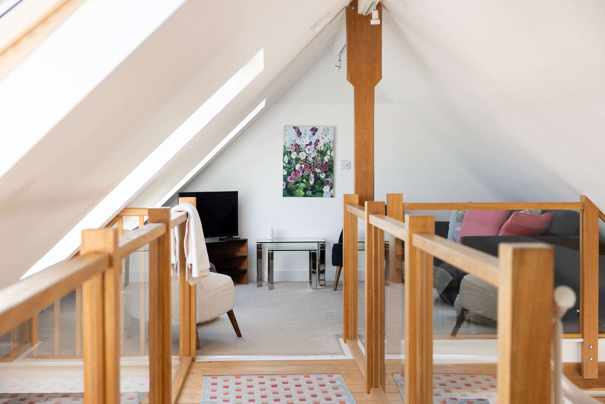 The cosy upstairs living room with TV and comfy seating.