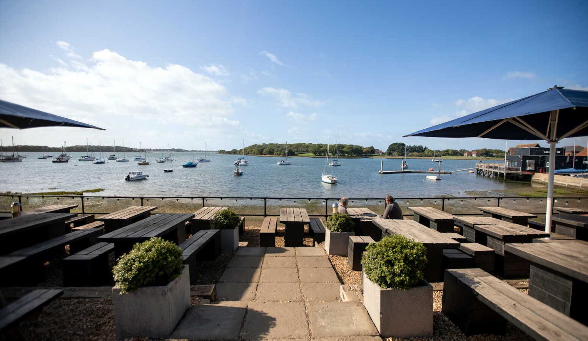 Enjoy amazing waterside views from the terrace at The Crown & Anchor, Chichester. Just a 12-minute drive away.