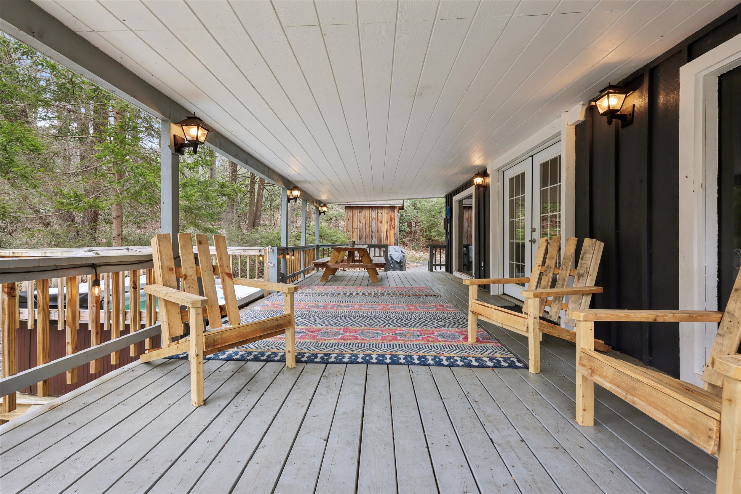 Relax on the covered deck with Adirondack seating and the hot tub just steps away.