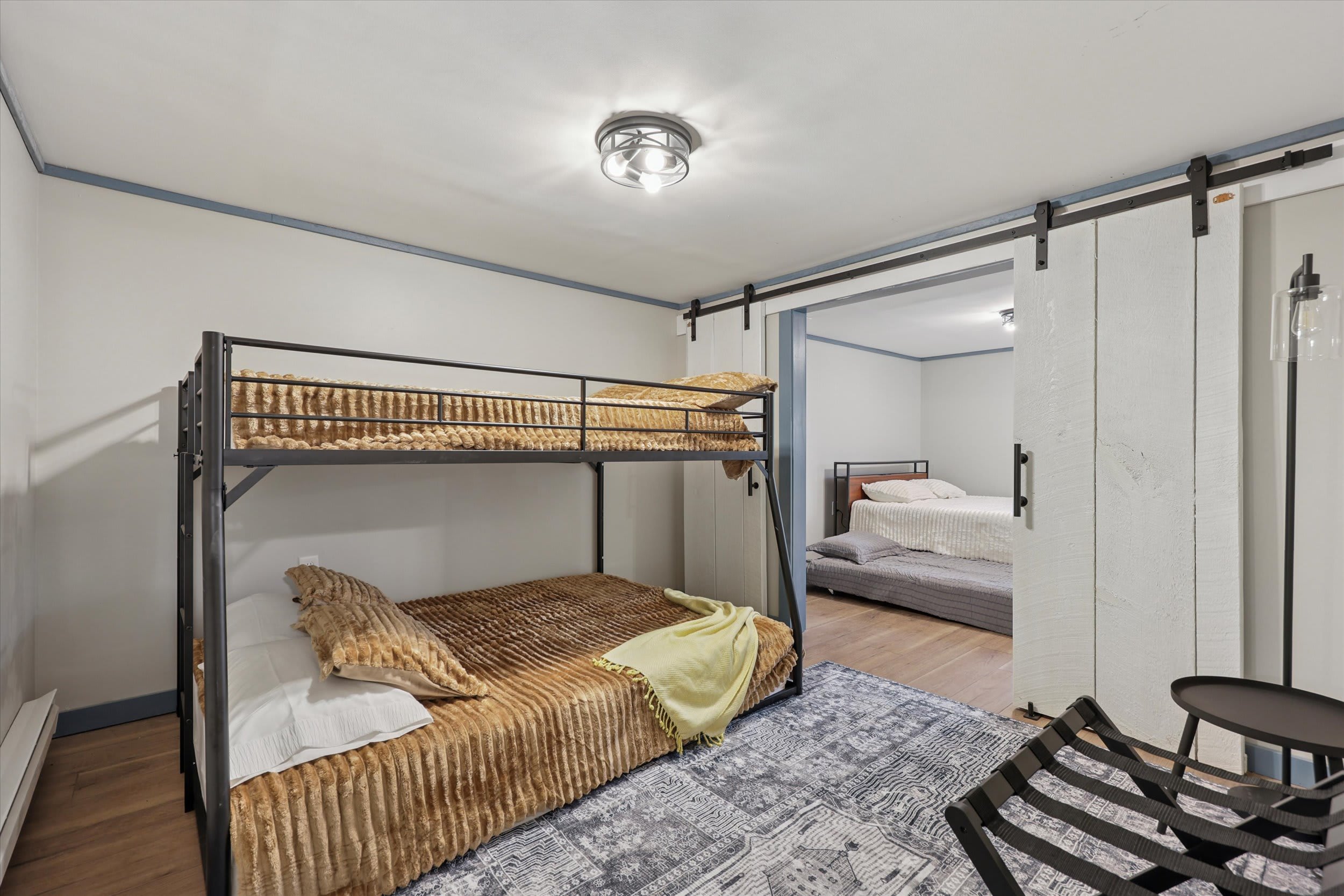 A cozy bunk bed room with sliding barn door is perfect for little adventurers.