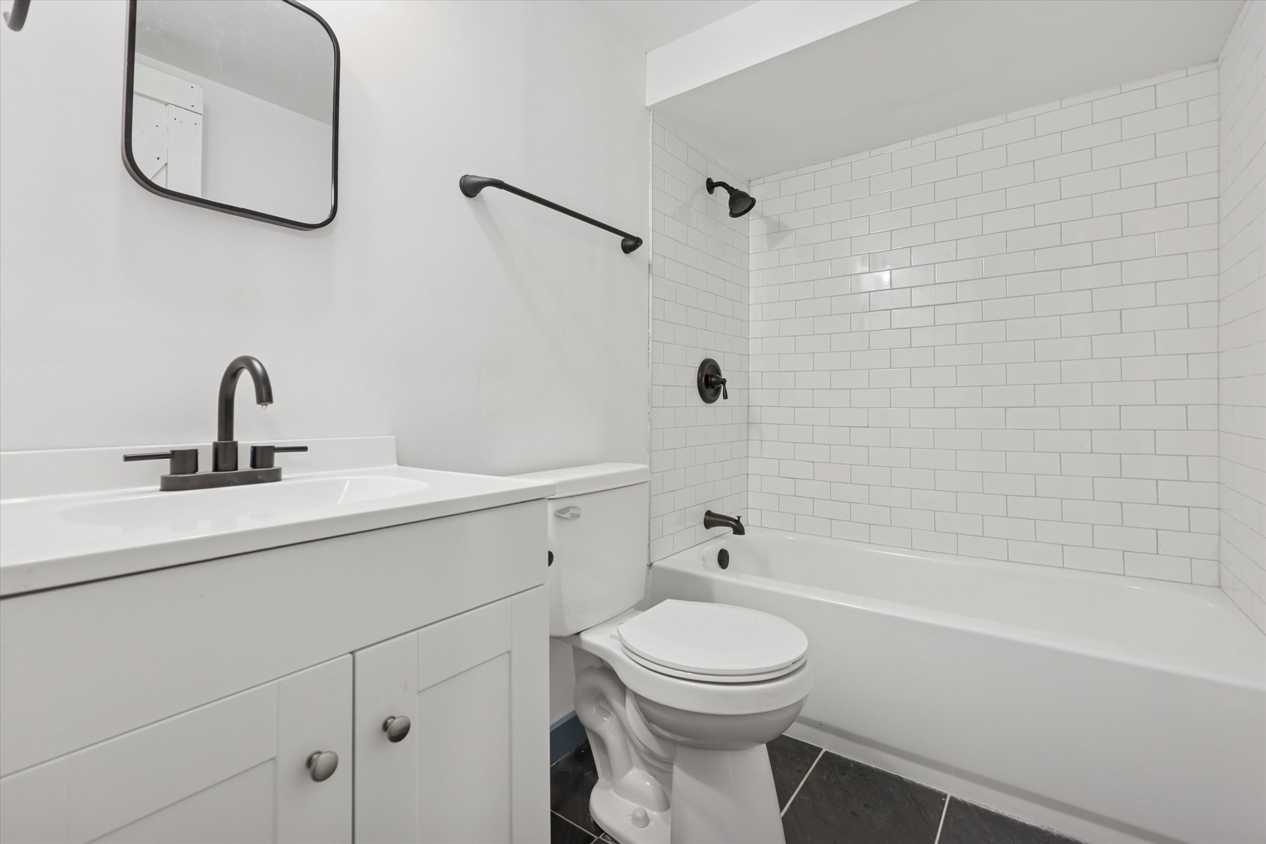 The clean, modern lower-level bathroom features a tub-shower combo and stylish matte fixtures.