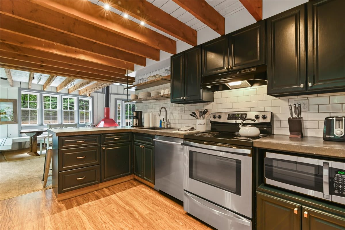 The fully equipped kitchen flows into the sunny dining room with floor-to-ceiling views.
