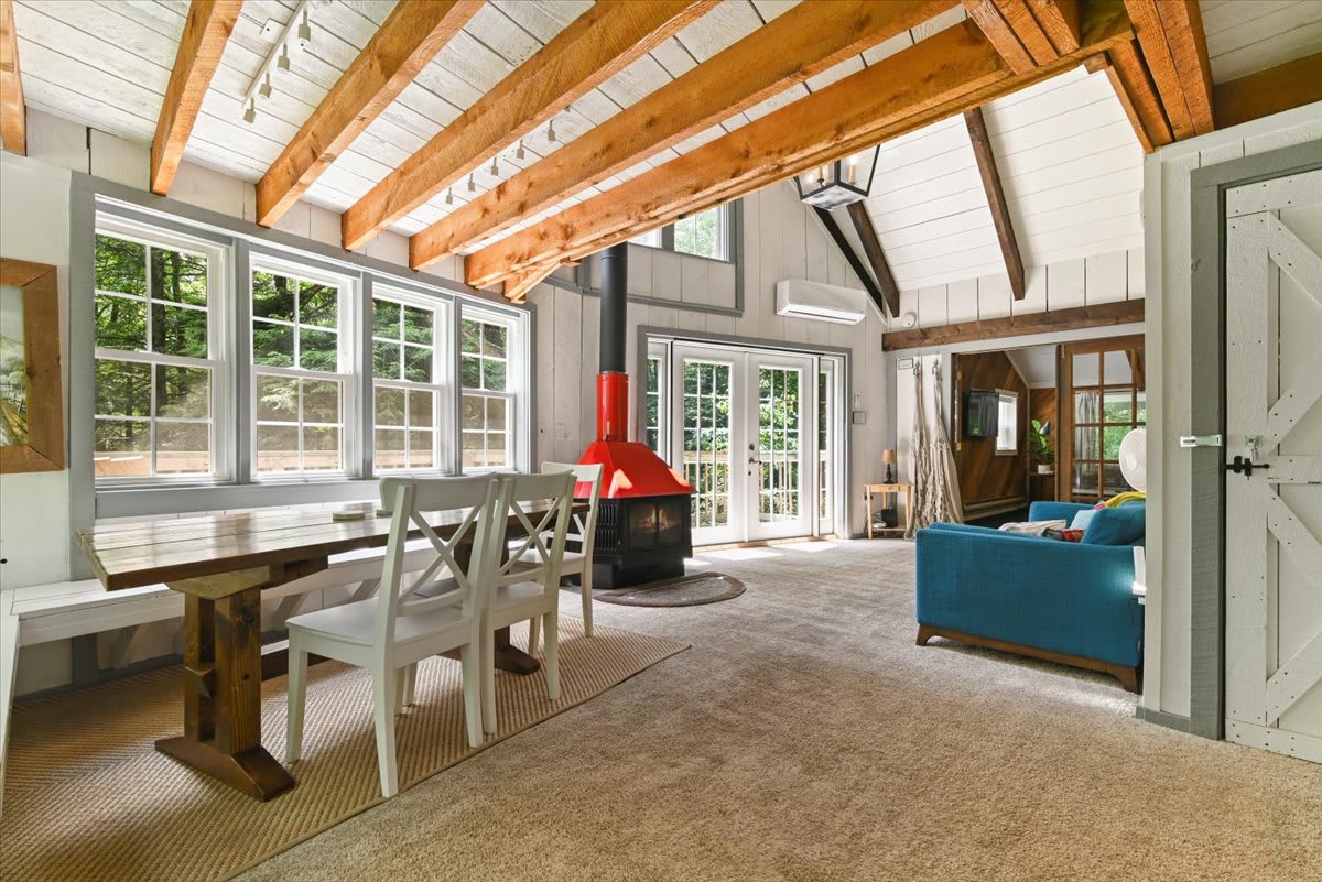 Enjoy family meals by the wood fireplace in this sun-filled dining room with forest views.