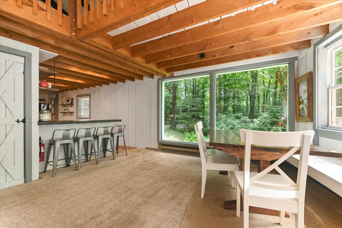 Step outside from the living room to enjoy meals on the covered deck with forest views.