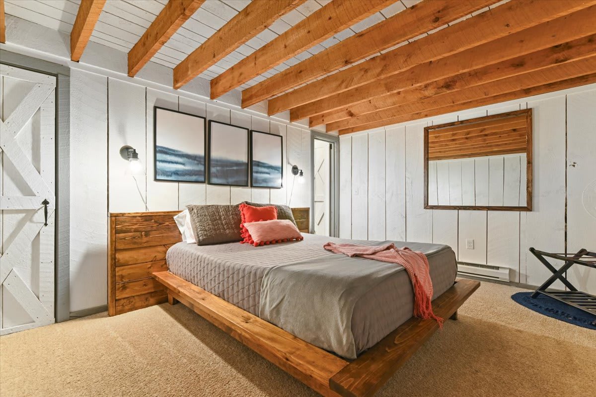 Drift off in the master bedroom with coastal artwork and soft coral accents.