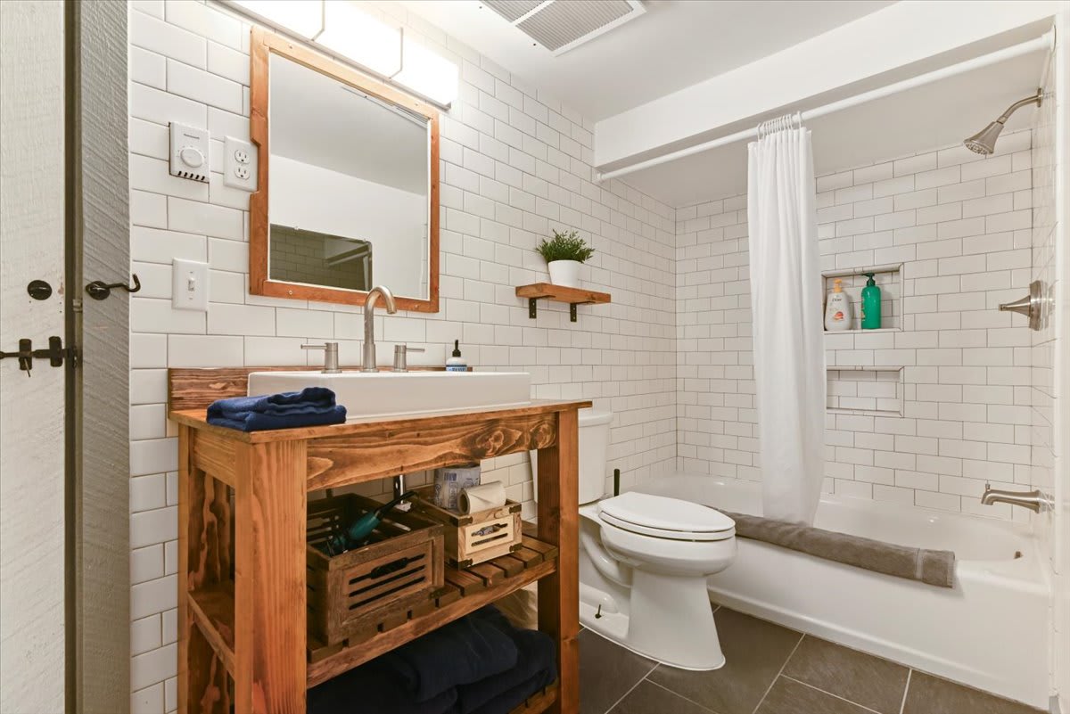 The charming main-level bathroom blends rustic wood accents with clean subway tile.