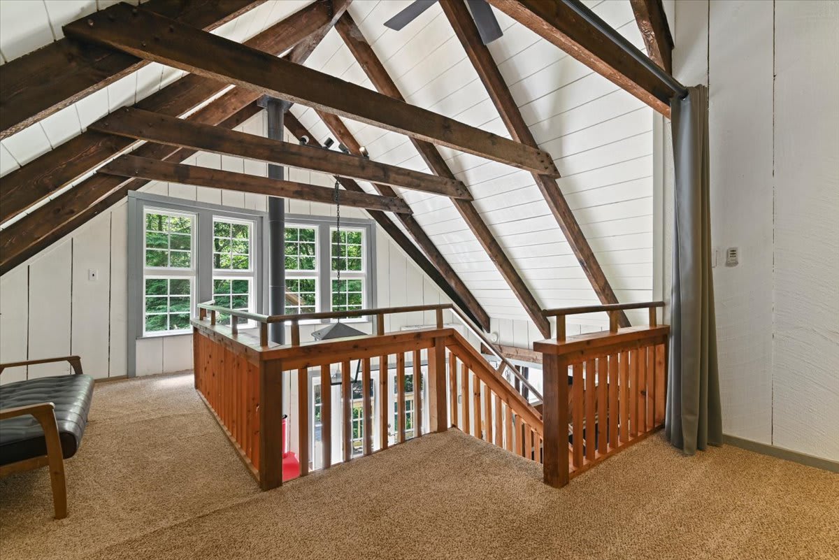 The loft showcases stunning A-frame architecture with exposed beams and treetop views.