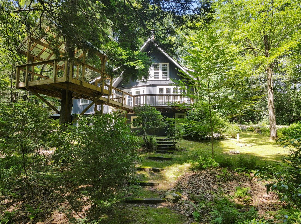 The A-frame chalet sits peacefully among towering trees with a spacious yard.