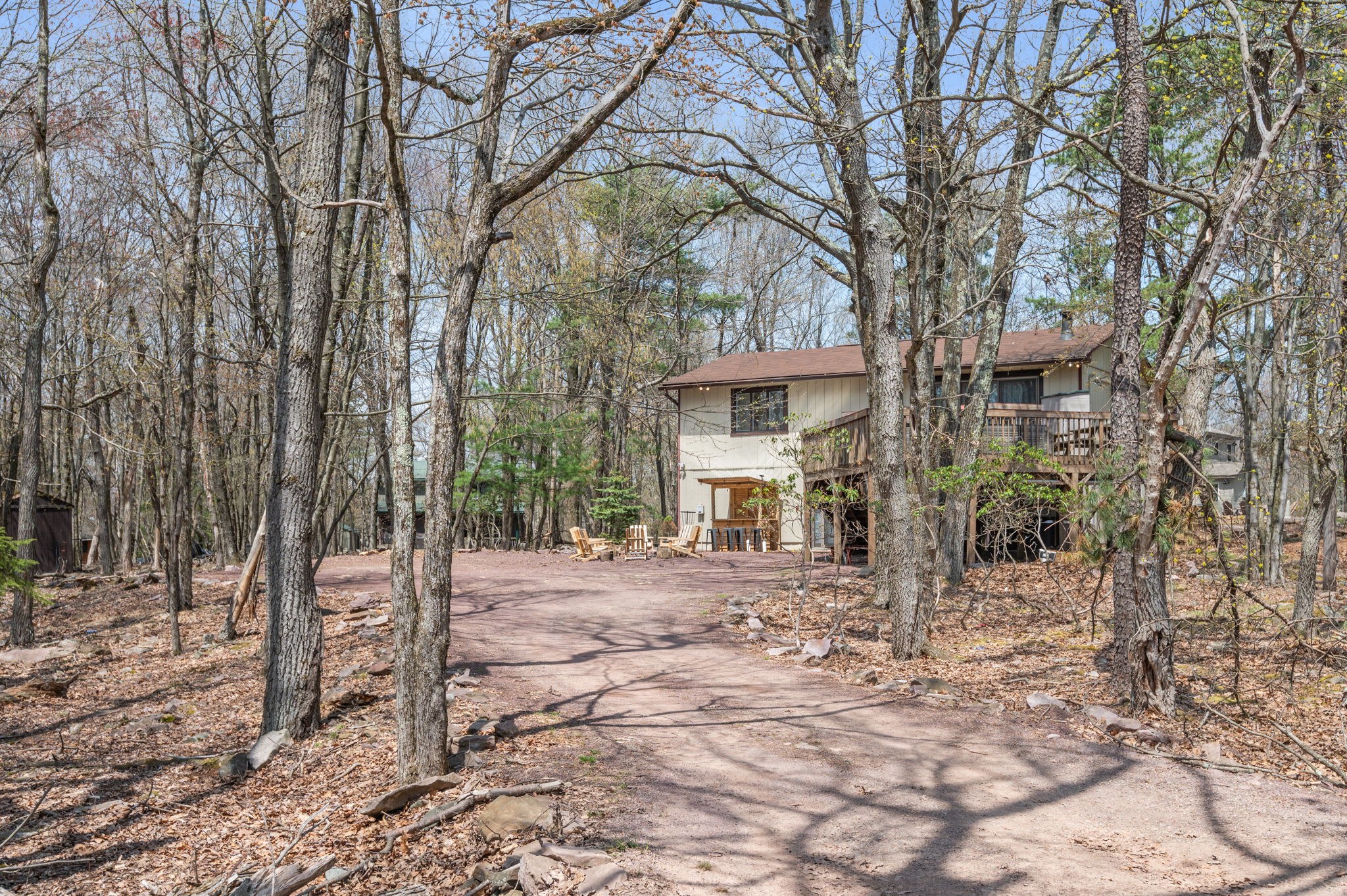 Your Poconos retreat awaits with this charming two-story lodge nestled among the trees