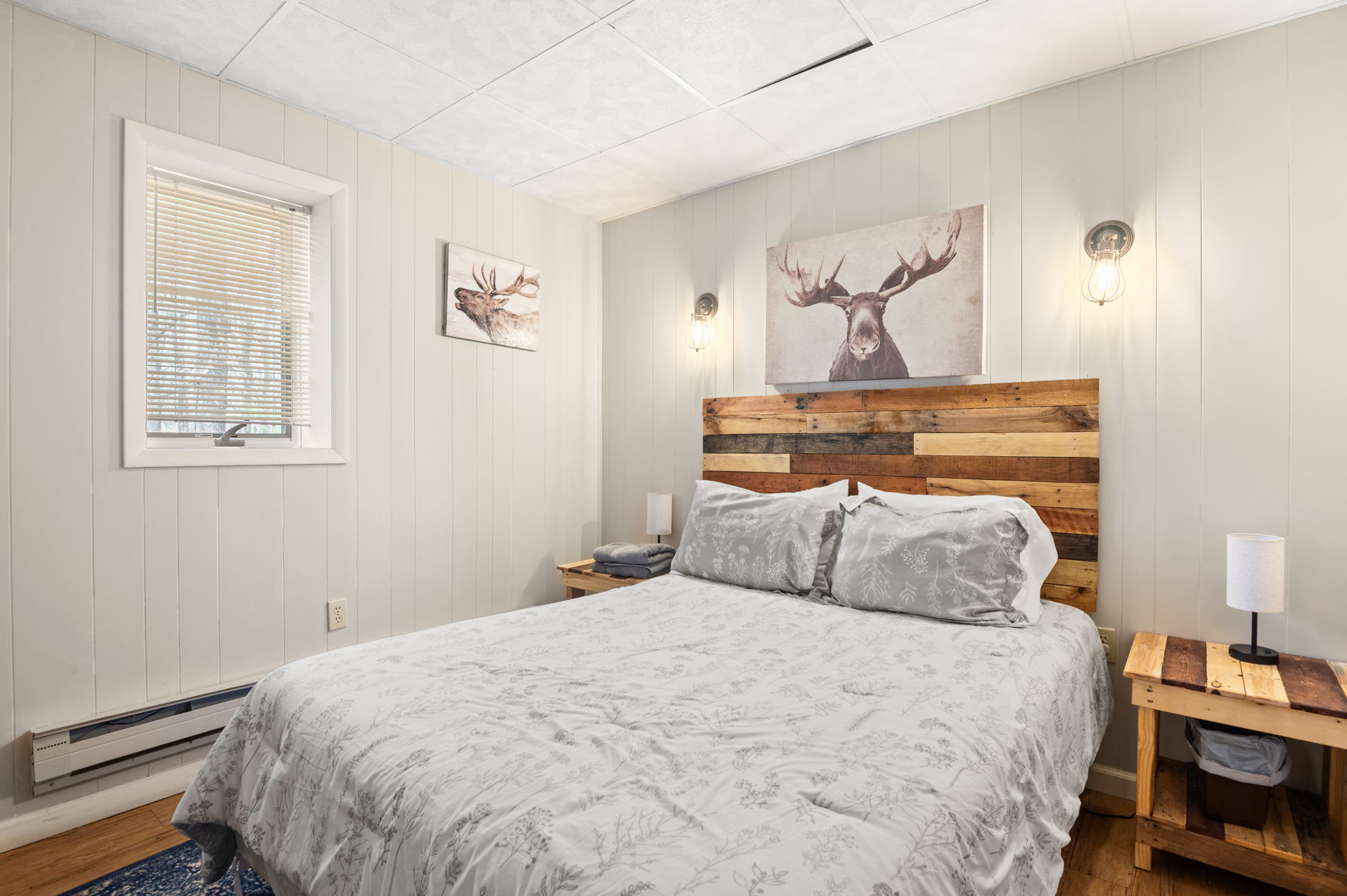 Rest easy in this sunlit bedroom with cozy comforter and charming wood accents