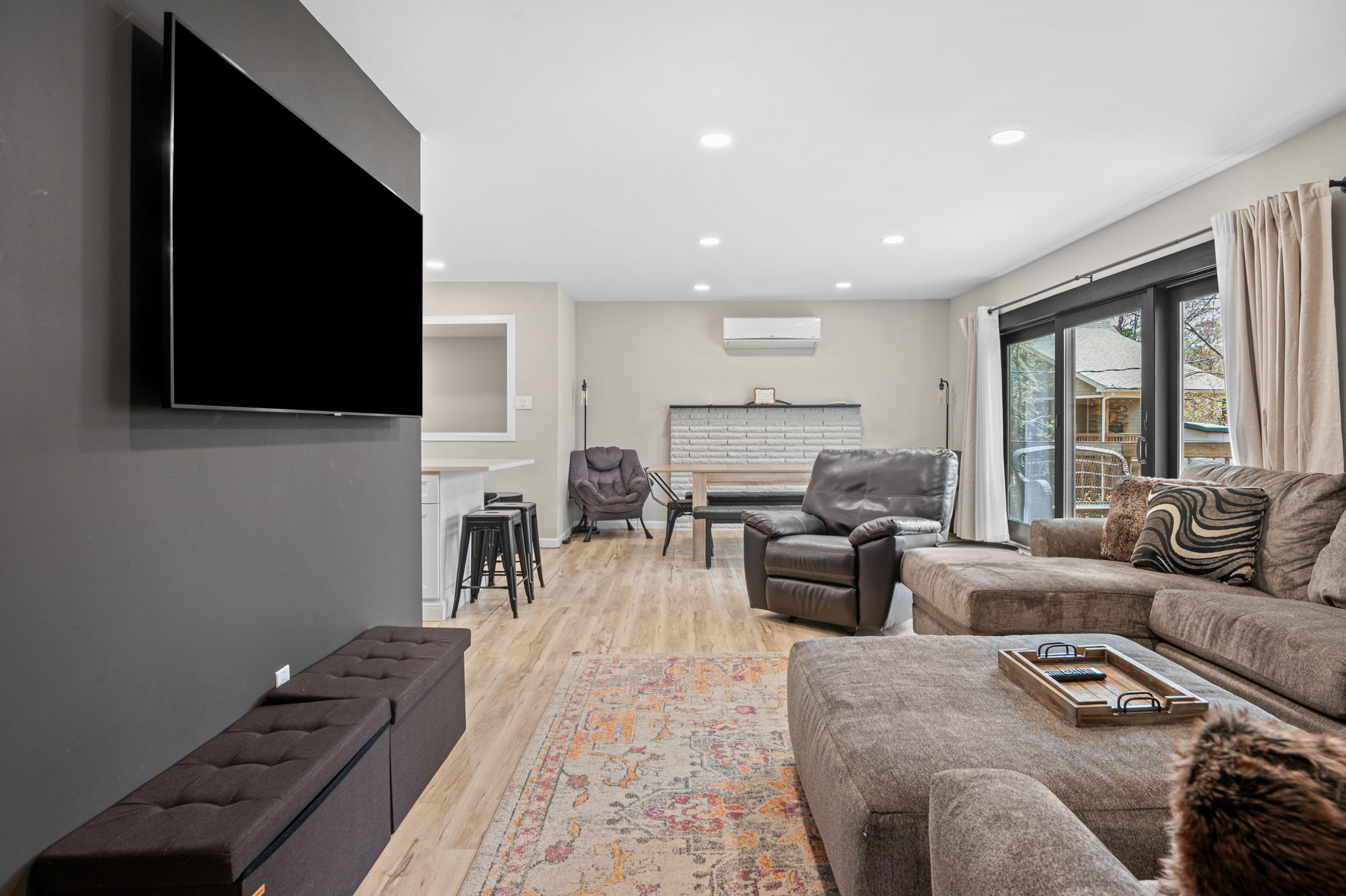 Cozy living room with wall-mounted TV and comfy seating for the whole group
