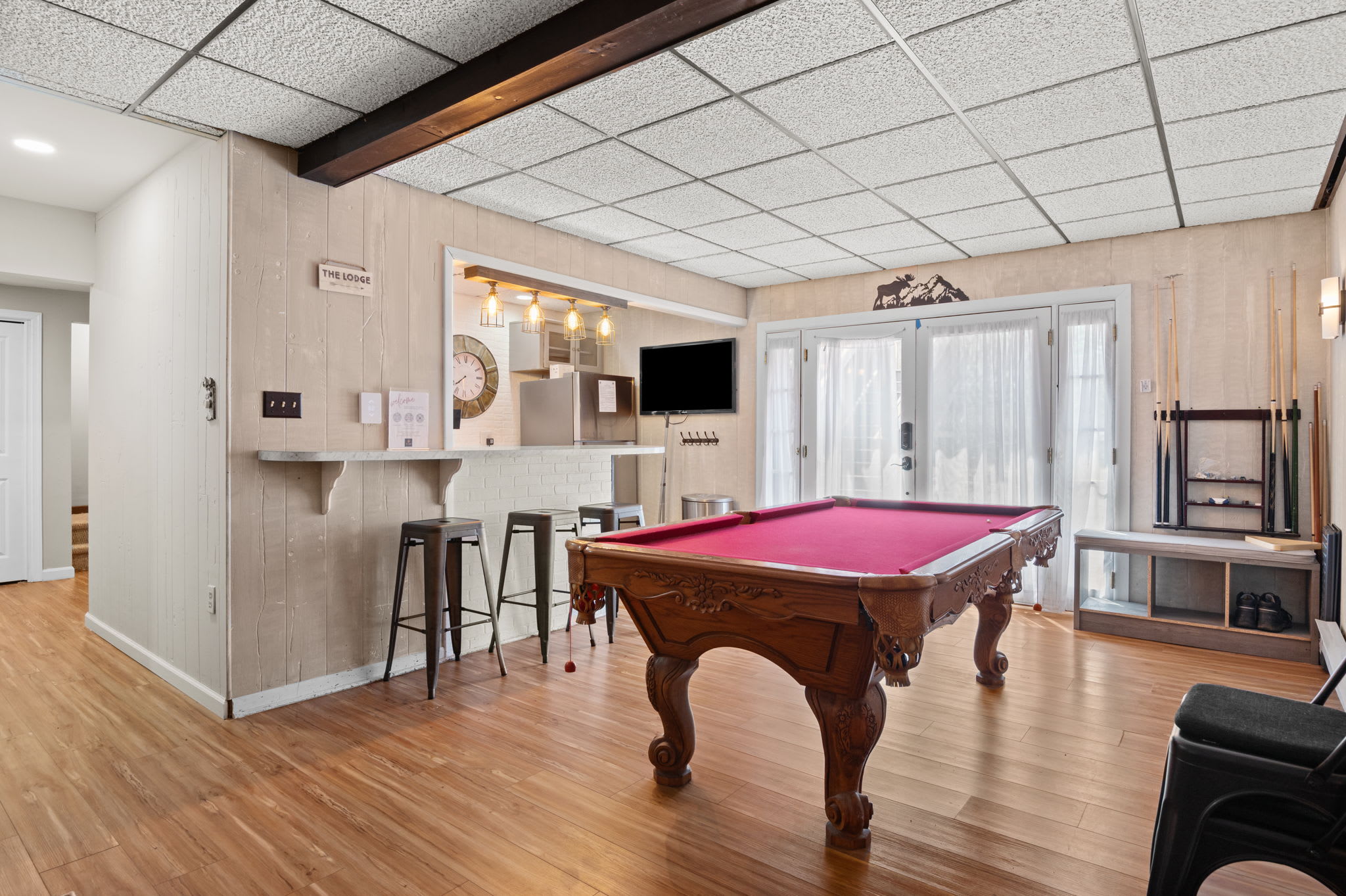 Rack up a game with cues ready and TV sports playing in the background