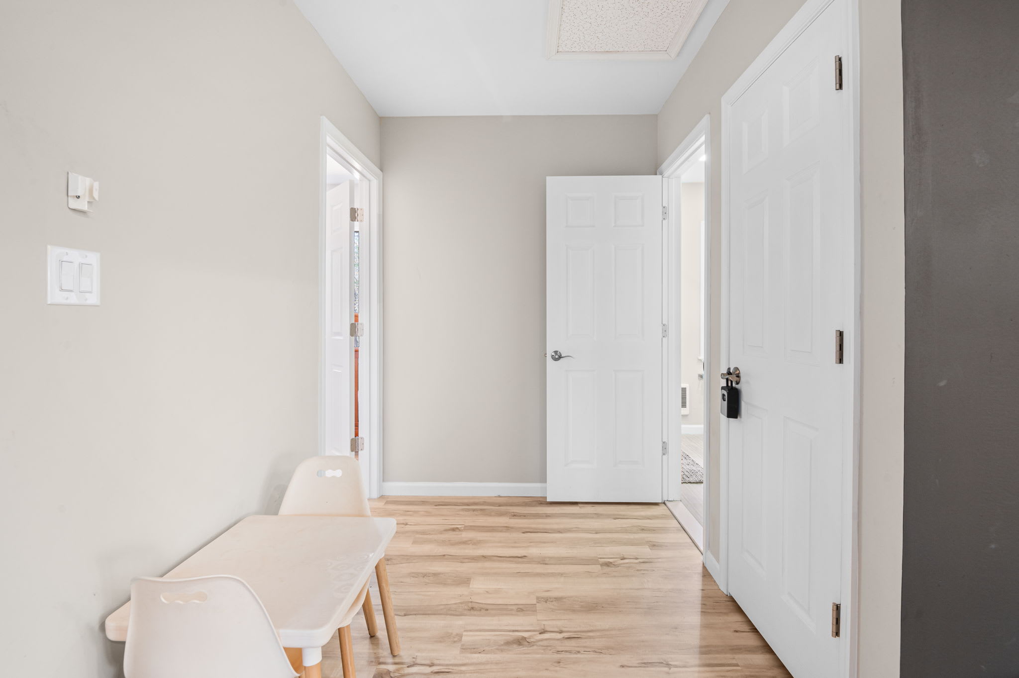 Bright hallway with hardwood floors and closet storage for easy access throughout the home