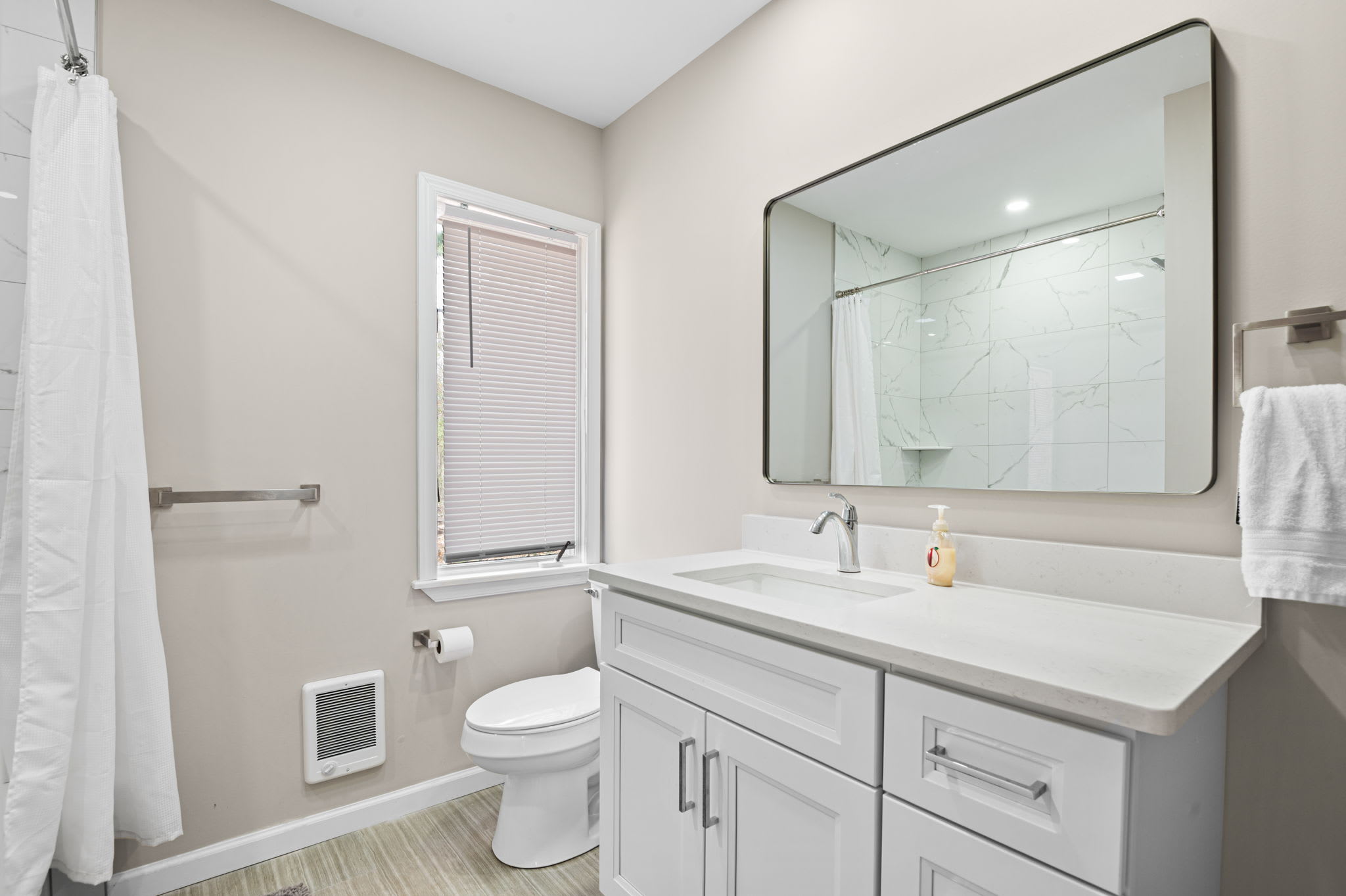 Clean modern bathroom with double vanity and bright lighting for your convenience