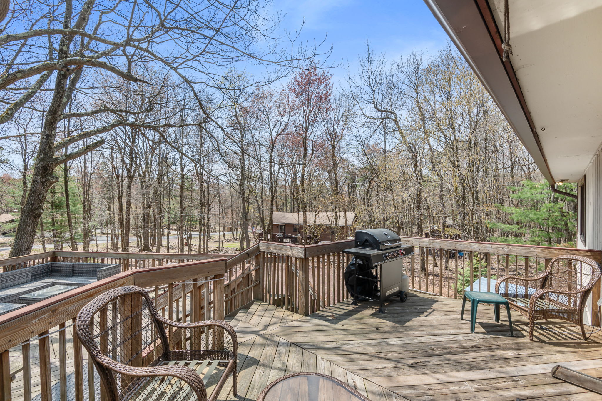 Step outside onto the spacious wooden deck with seating to enjoy your morning coffee in the trees