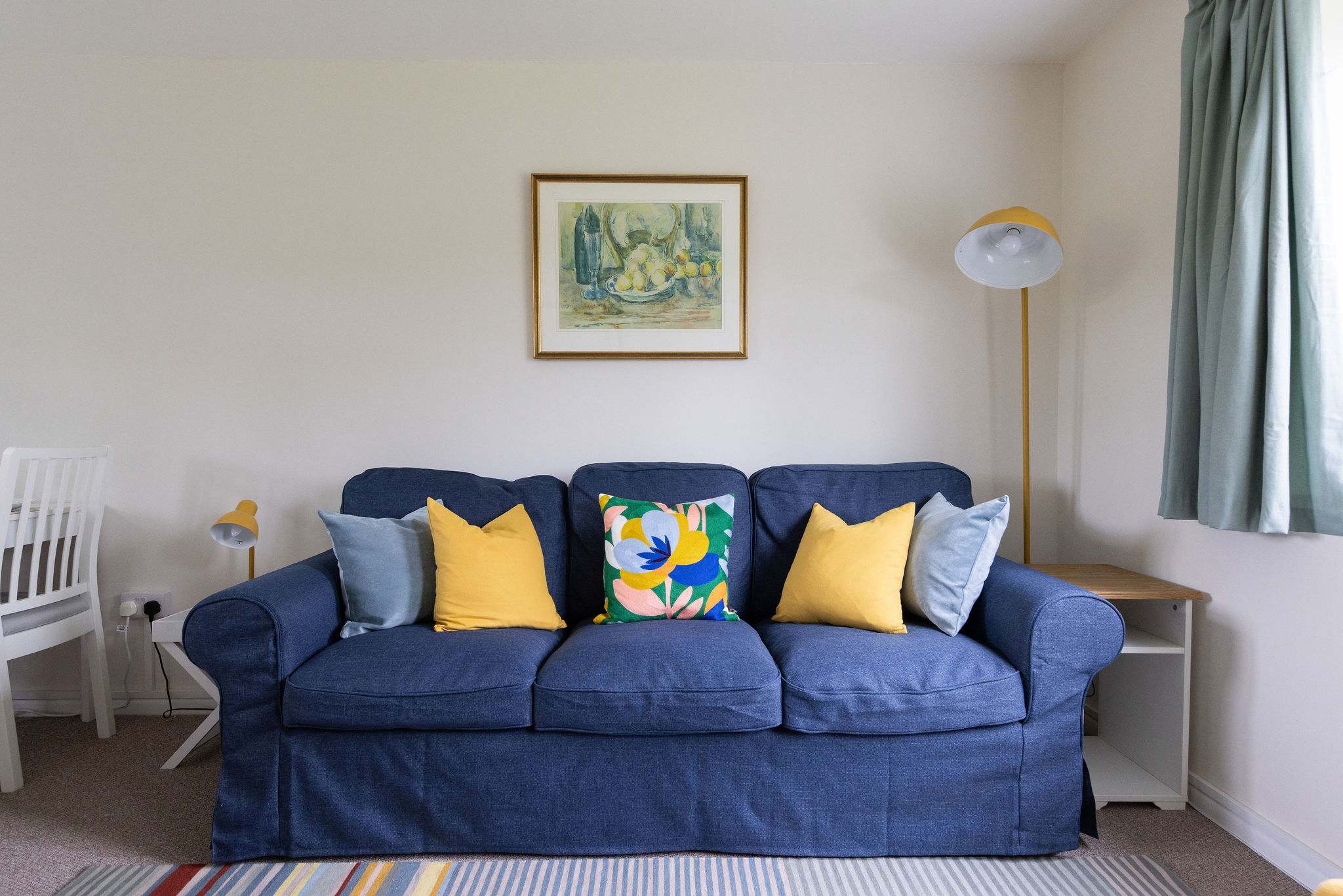 Perfect for lounging with this cosy blue couch adorned with cheerful yellow pillows!