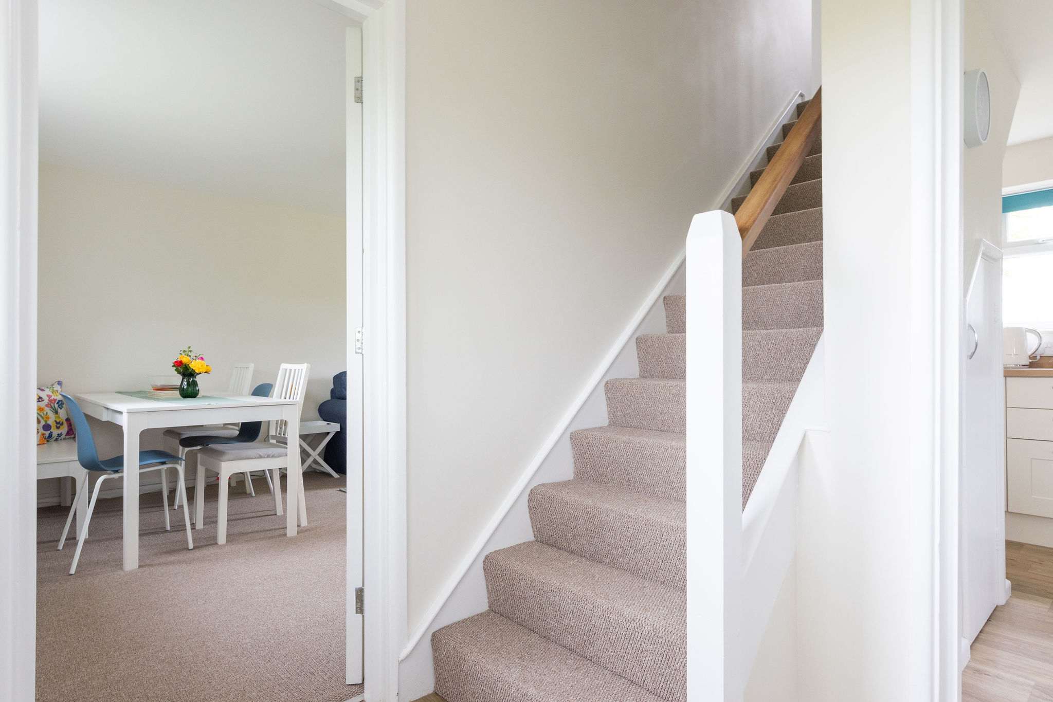Dining area and kitchen area separated by stairs.