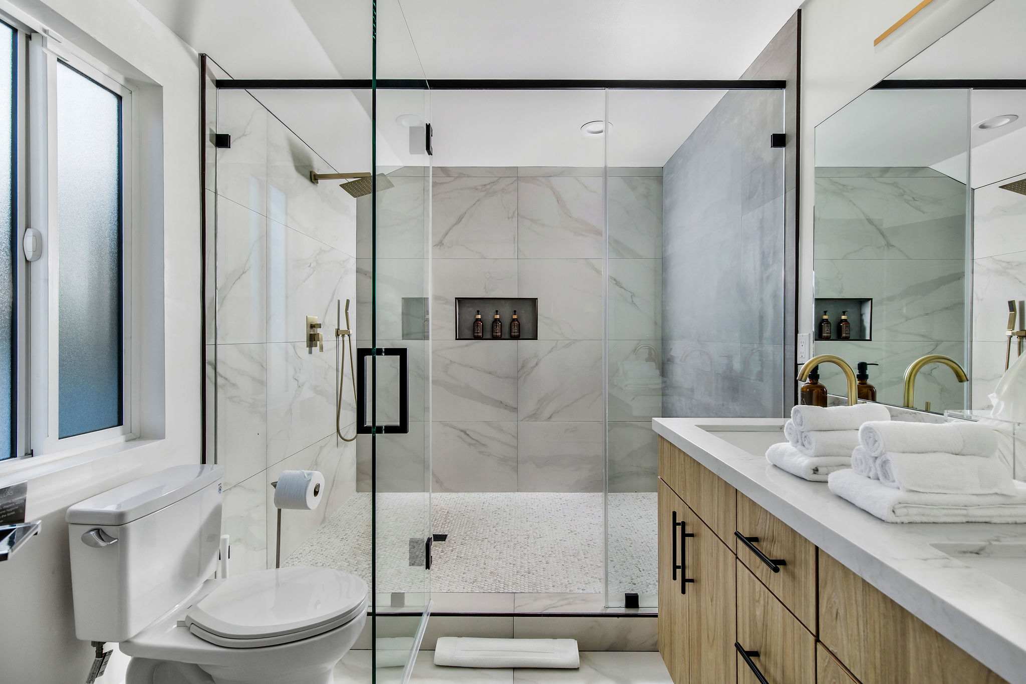 Step into the shower framed in stone and black steel