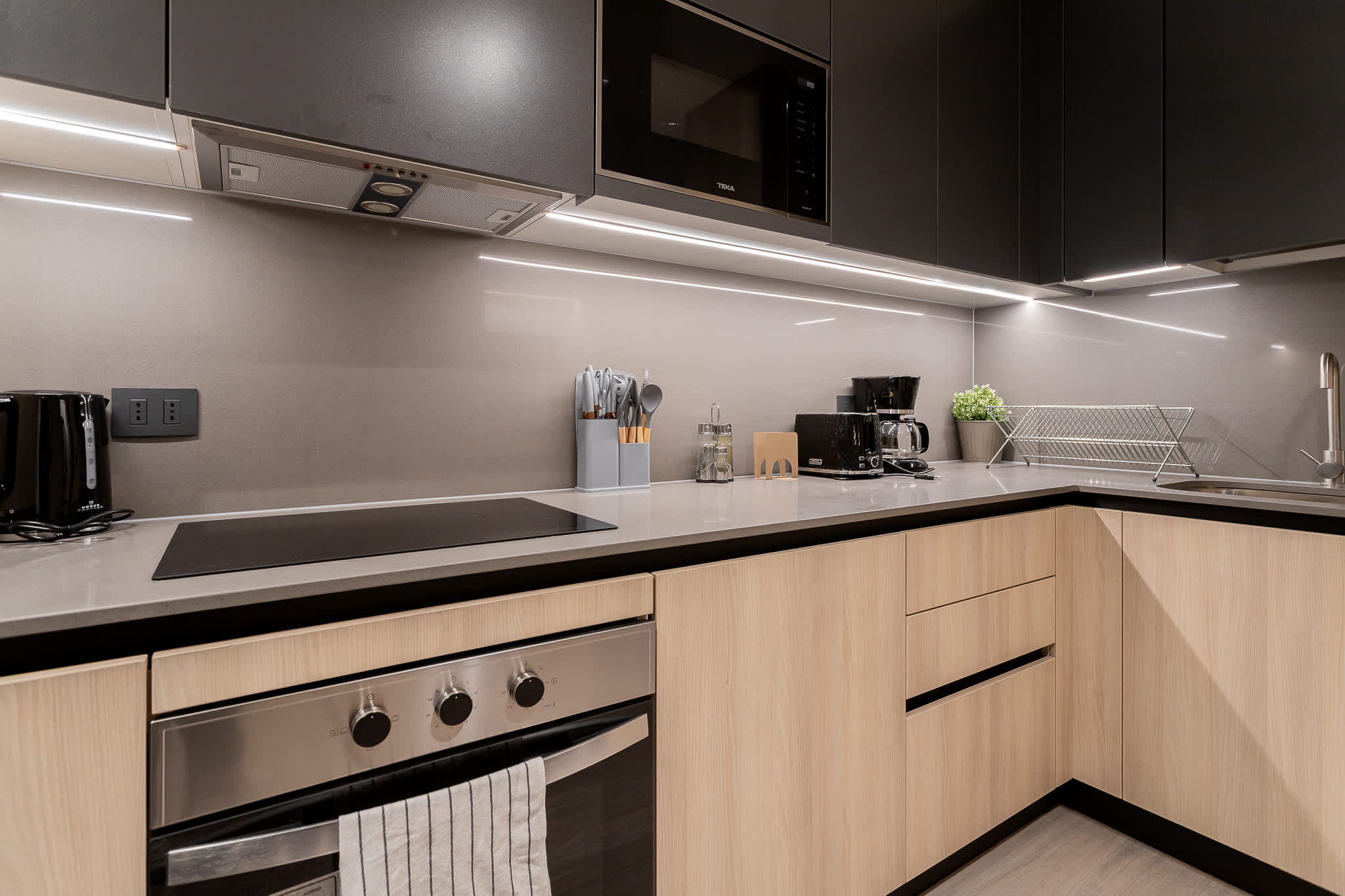 Experience culinary delight in this sleek, modern kitchen equipped with top-notch appliances and stylish finishes.