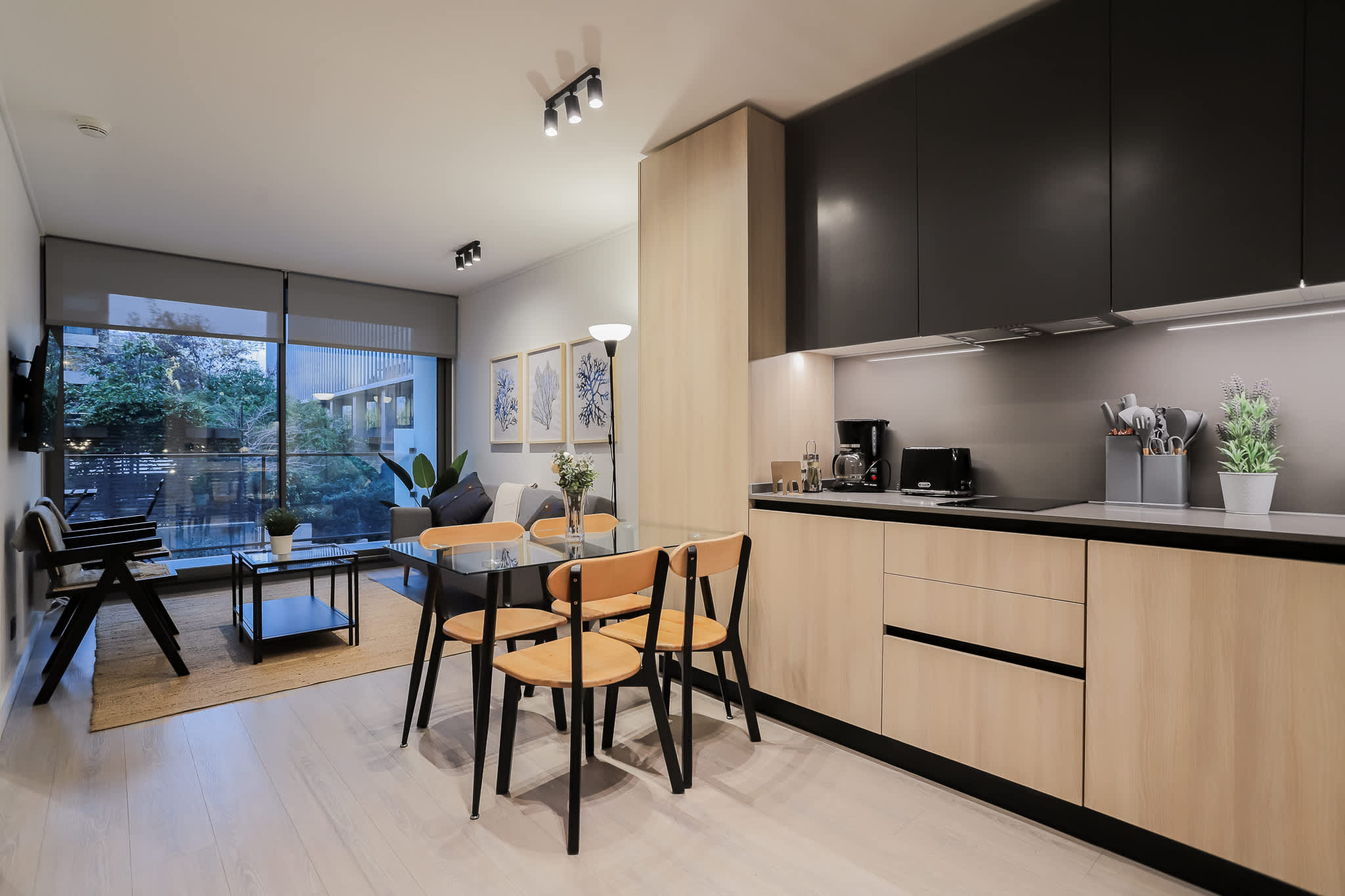 Modern open-plan living with a sleek kitchen, cozy seating, and a stunning view through floor-to-ceiling windows. Perfect for relaxation and entertaining!