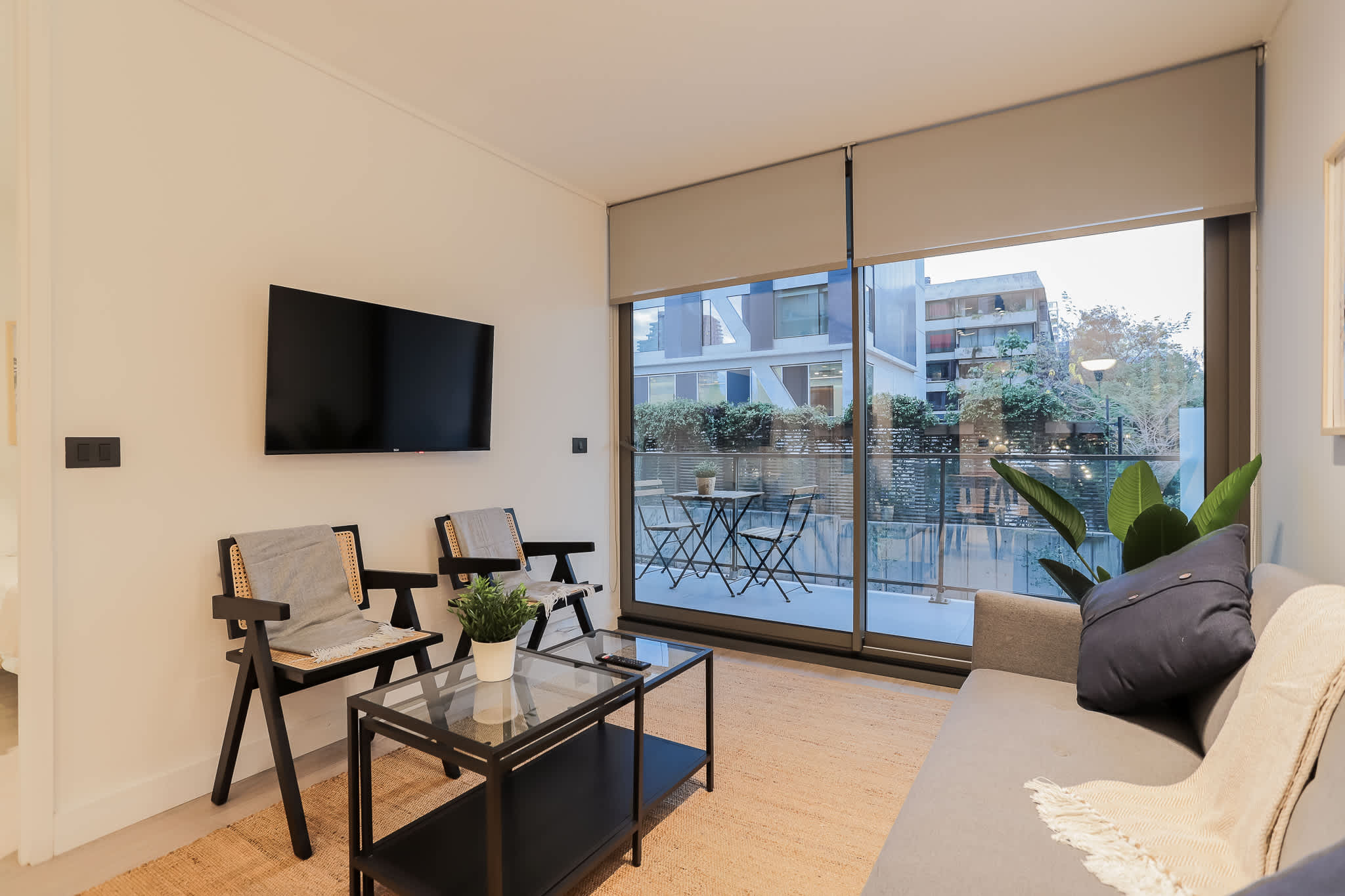 Relax in this modern living room with balcony views, stylish seating, and a sleek TV setup—perfect for unwinding after a day of exploring.
