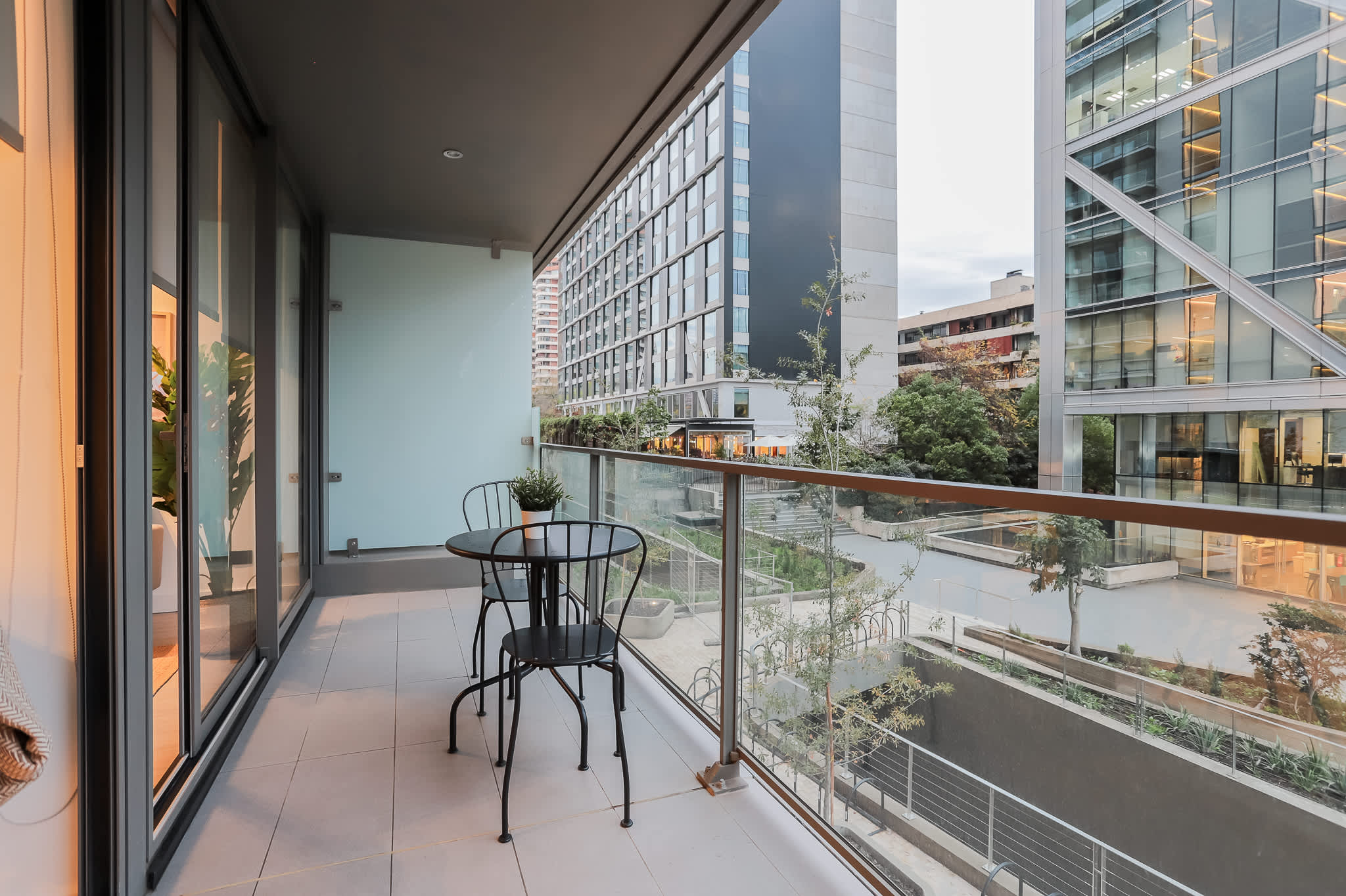 Enjoy your morning coffee on this sleek terrace with city views and lush greenery.