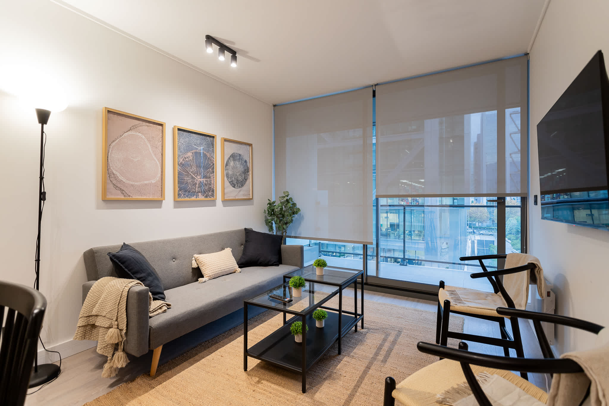 Relax in this chic living room with a modern sofa, stylish decor, and a view of the city skyline through expansive windows.