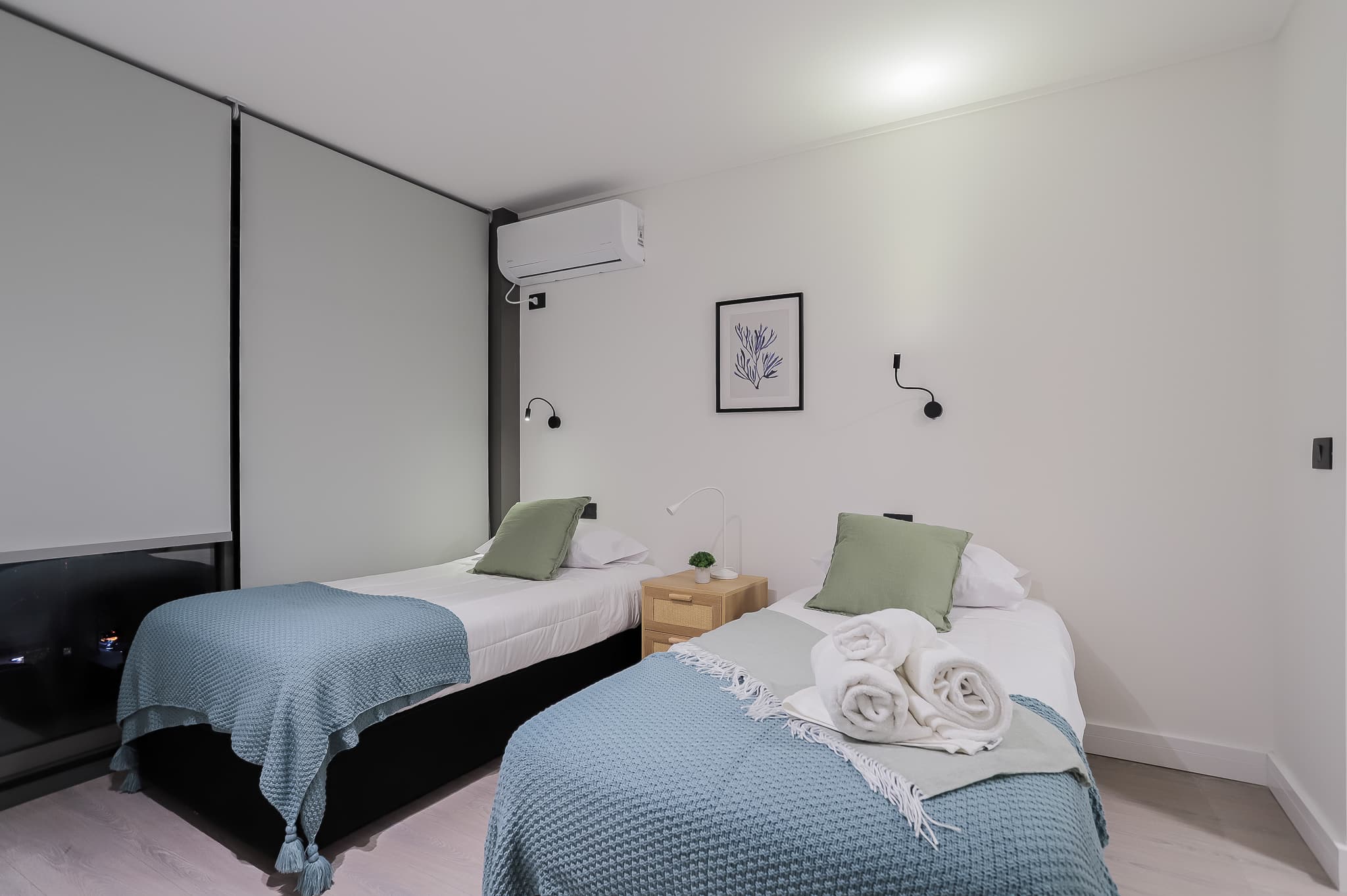 Cozy twin bedroom with modern decor and soft lighting, perfect for a restful night's sleep.