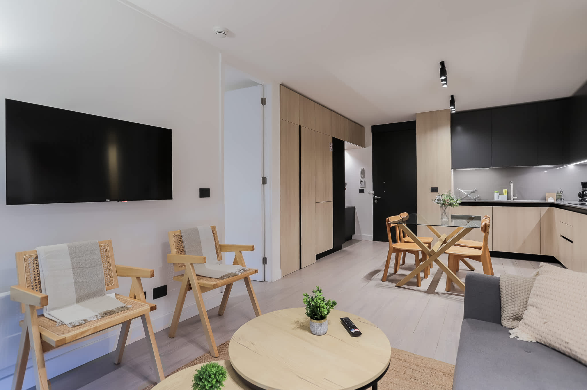 Experience modern comfort in this stylish open-plan living area with sleek kitchen and cozy seating, perfect for relaxation and dining.