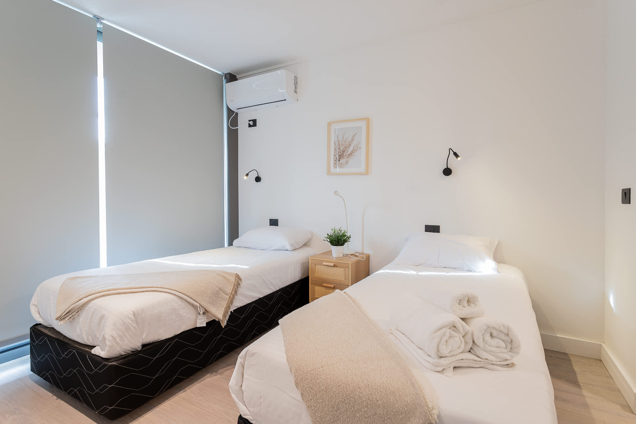 Bright and cozy bedroom with two single beds, perfect for a restful night's sleep in a minimalist setting.