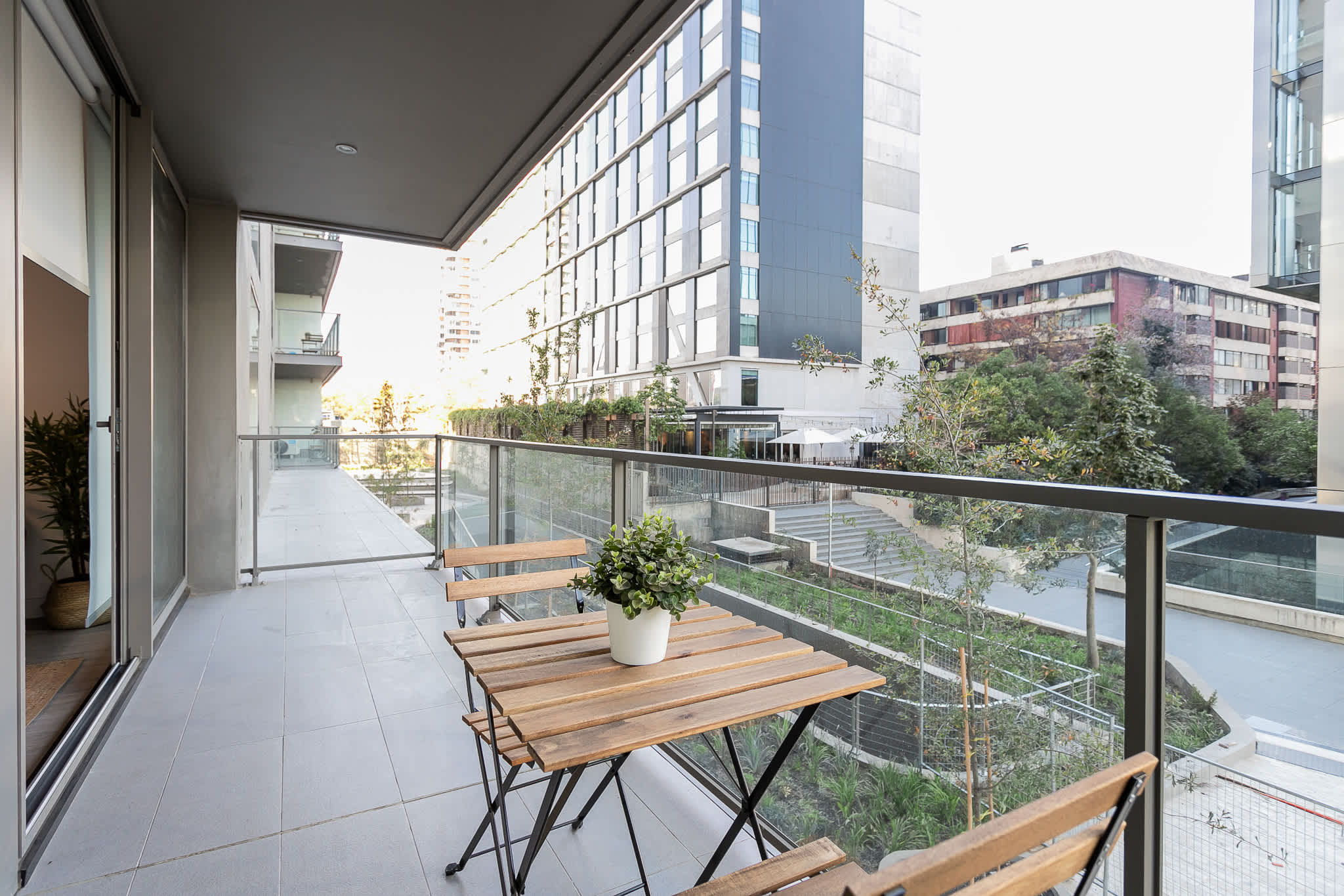 Enjoy your morning coffee on this private balcony with stunning city views and lush greenery.
