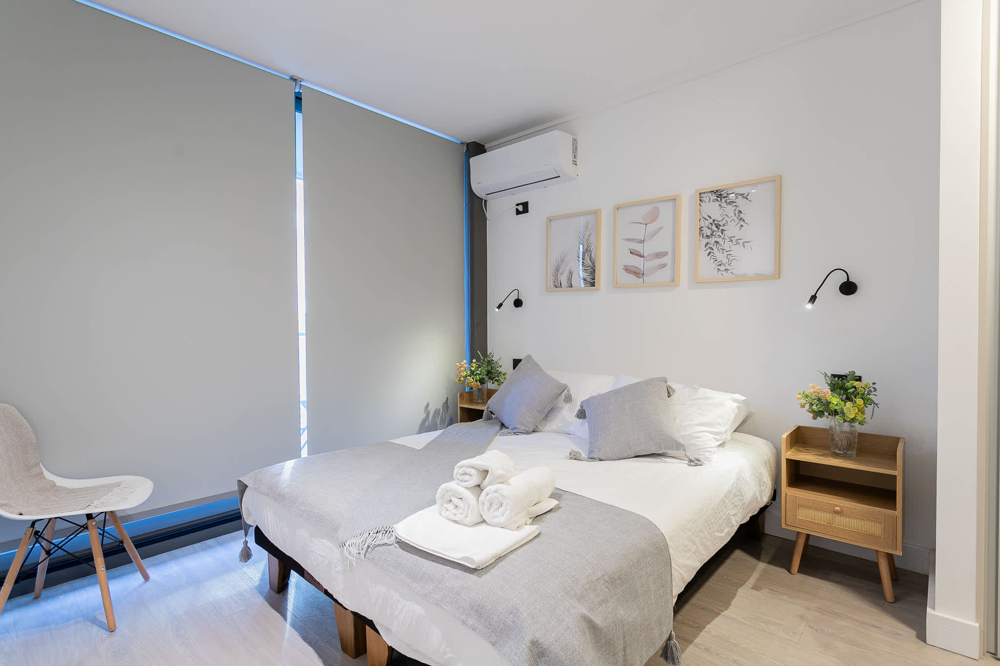 Relax in this serene bedroom with cozy bedding, stylish decor, and modern amenities for a restful stay.