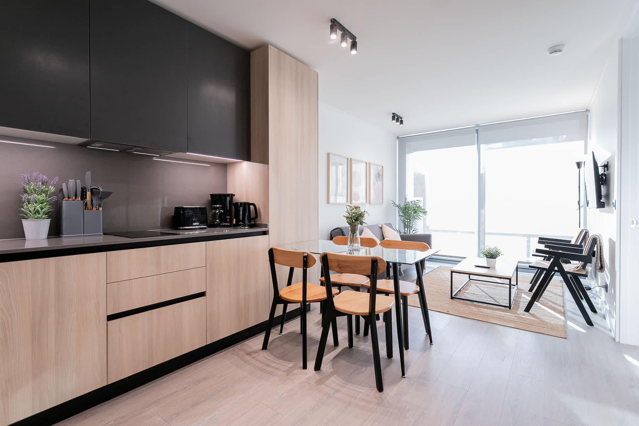 Experience modern living in this stylish studio with a sleek kitchen and cozy dining area, bathed in natural light.