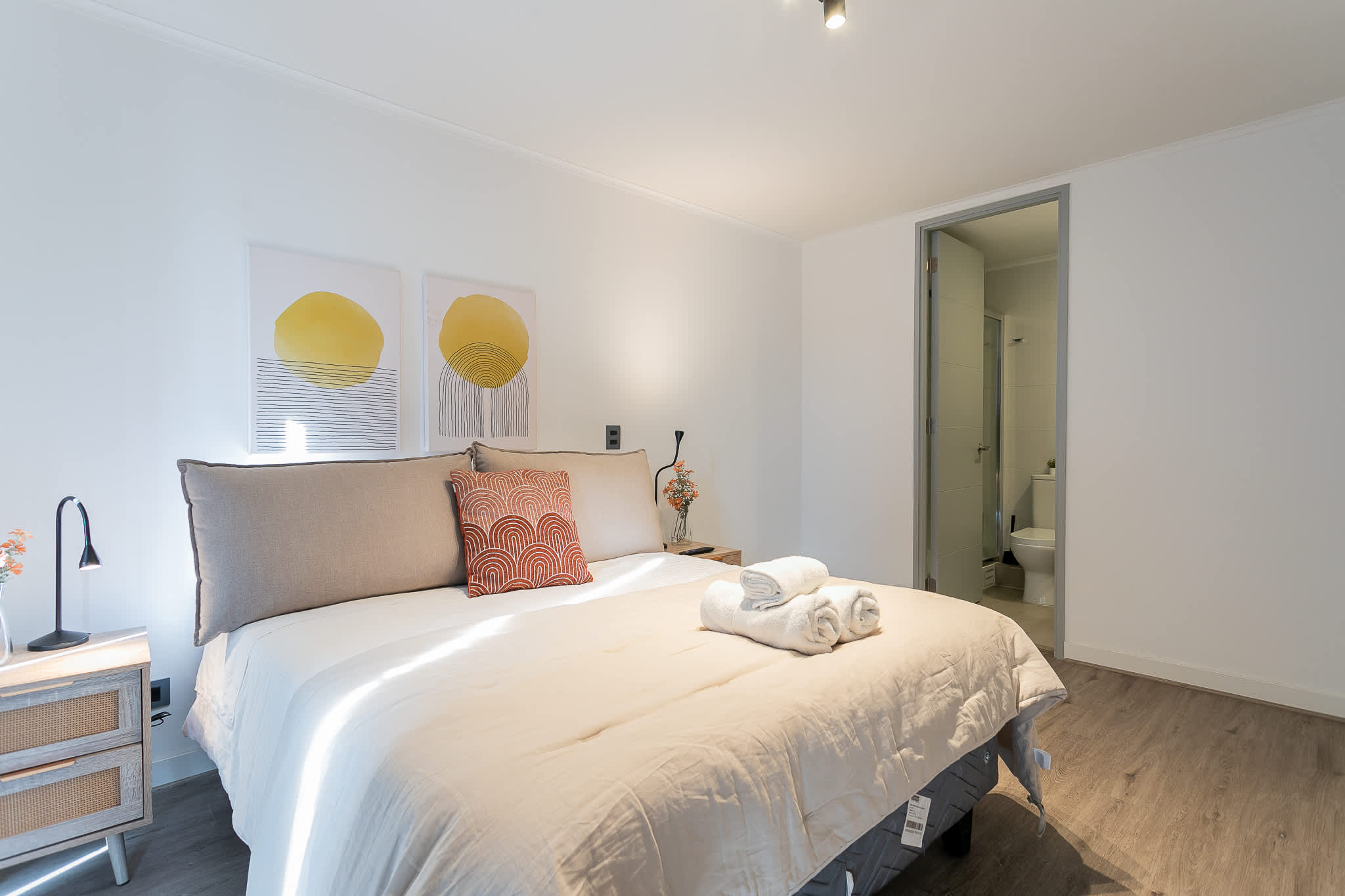 Relax in this serene bedroom with modern decor and an en-suite bathroom, perfect for a peaceful getaway.